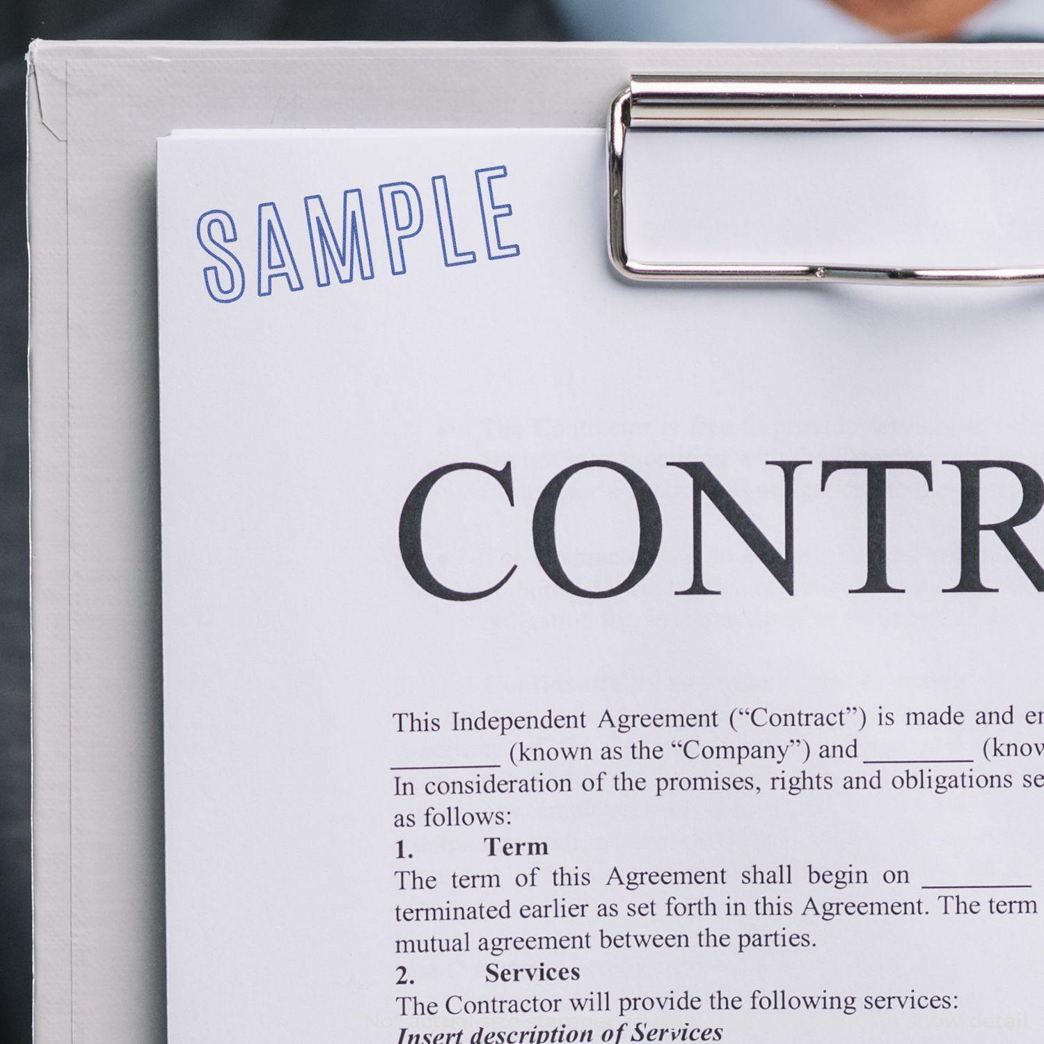 Sample Xstamper Stamp used on a contract document, showing the word 'SAMPLE' stamped in blue ink on the top left corner of the page."