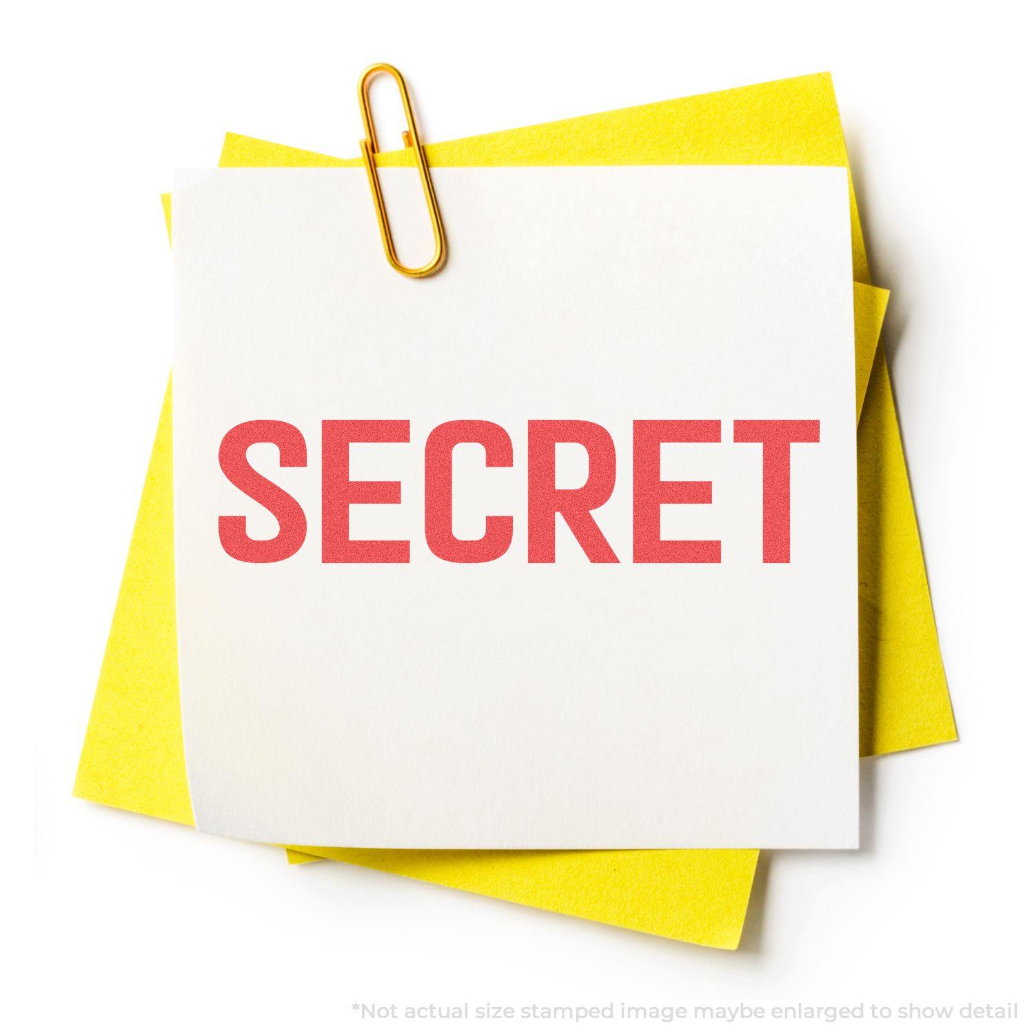 Secret Xstamper Stamp imprinting SECRET in red on a white note, clipped to yellow papers with a gold paperclip.