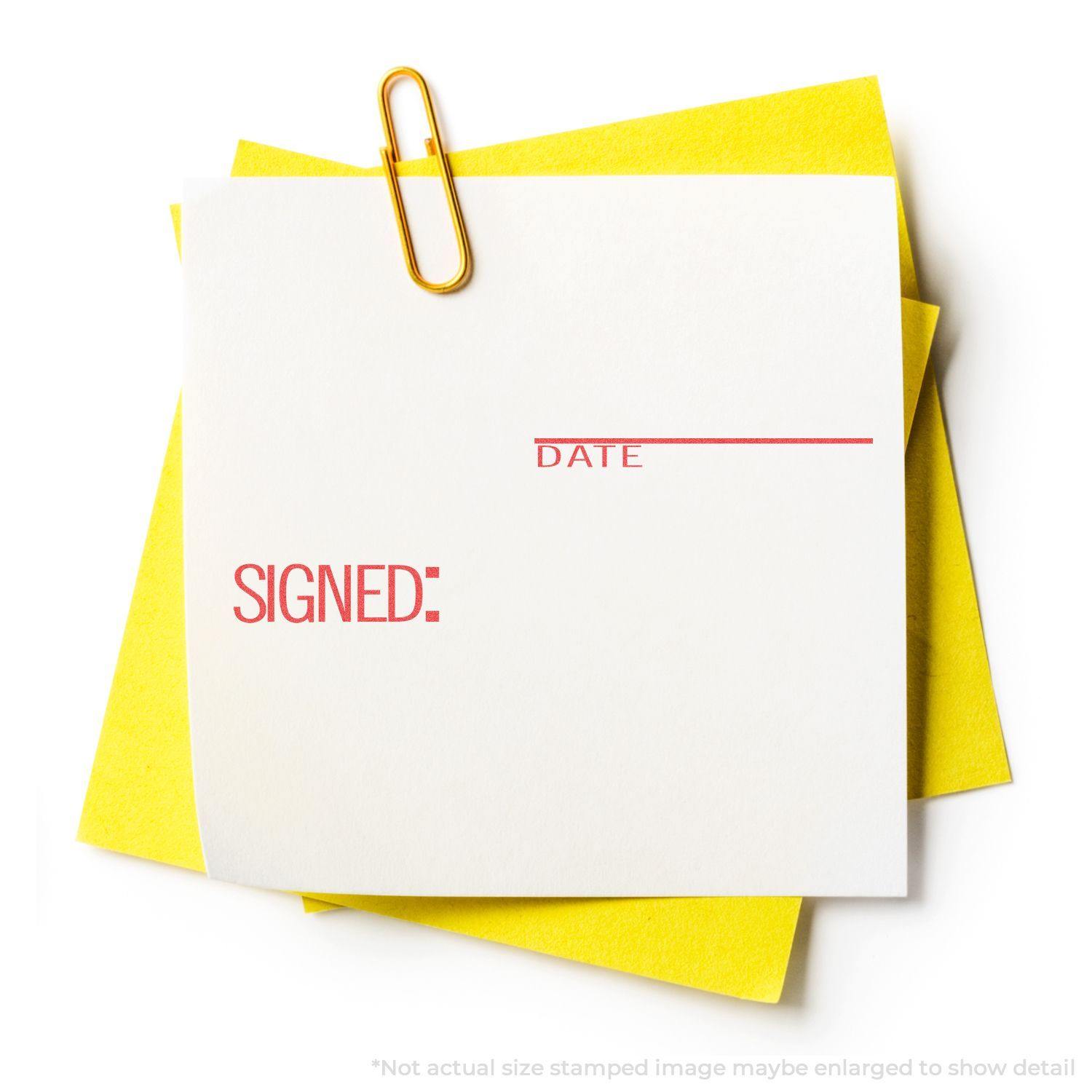Yellow paper with a white note stamped SIGNED: and DATE in red using the Signed: Date Xstamper Stamp, held by a gold paperclip.