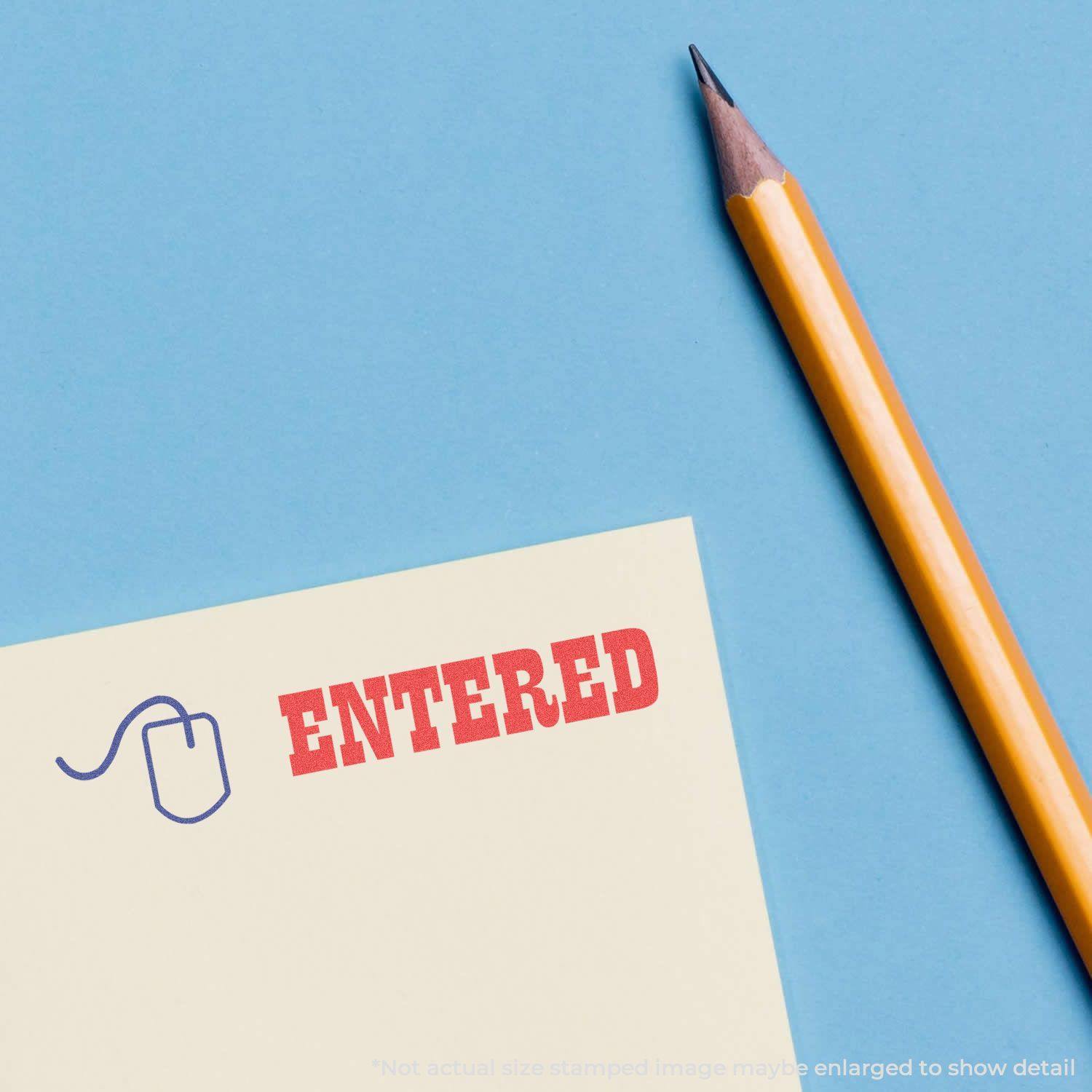 A Two-Color Entered Xstamper Stamp imprint on paper next to a yellow pencil, showing a red ENTERED text and a blue mouse icon.