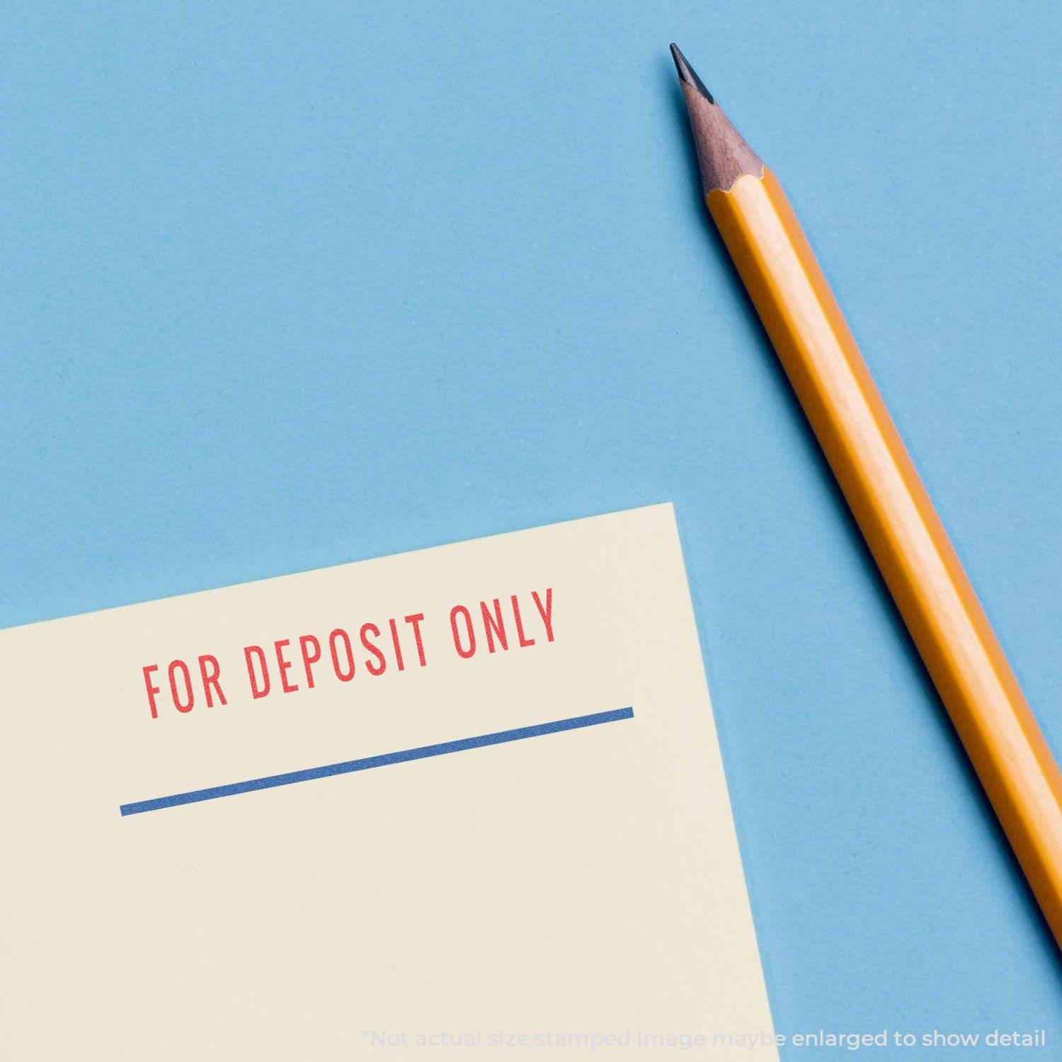 Two-Color For Deposit Only Xstamper Stamp used on a yellow paper with a pencil beside it on a blue background.