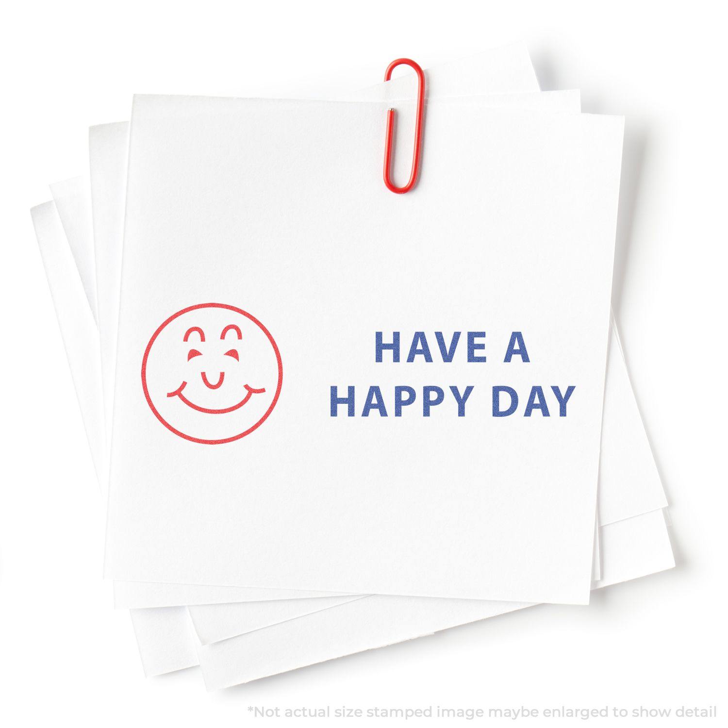 Two-Color Have A Happy Day Xstamper Stamp on white paper with a red smiley face and blue text saying HAVE A HAPPY DAY, clipped with a red paperclip.