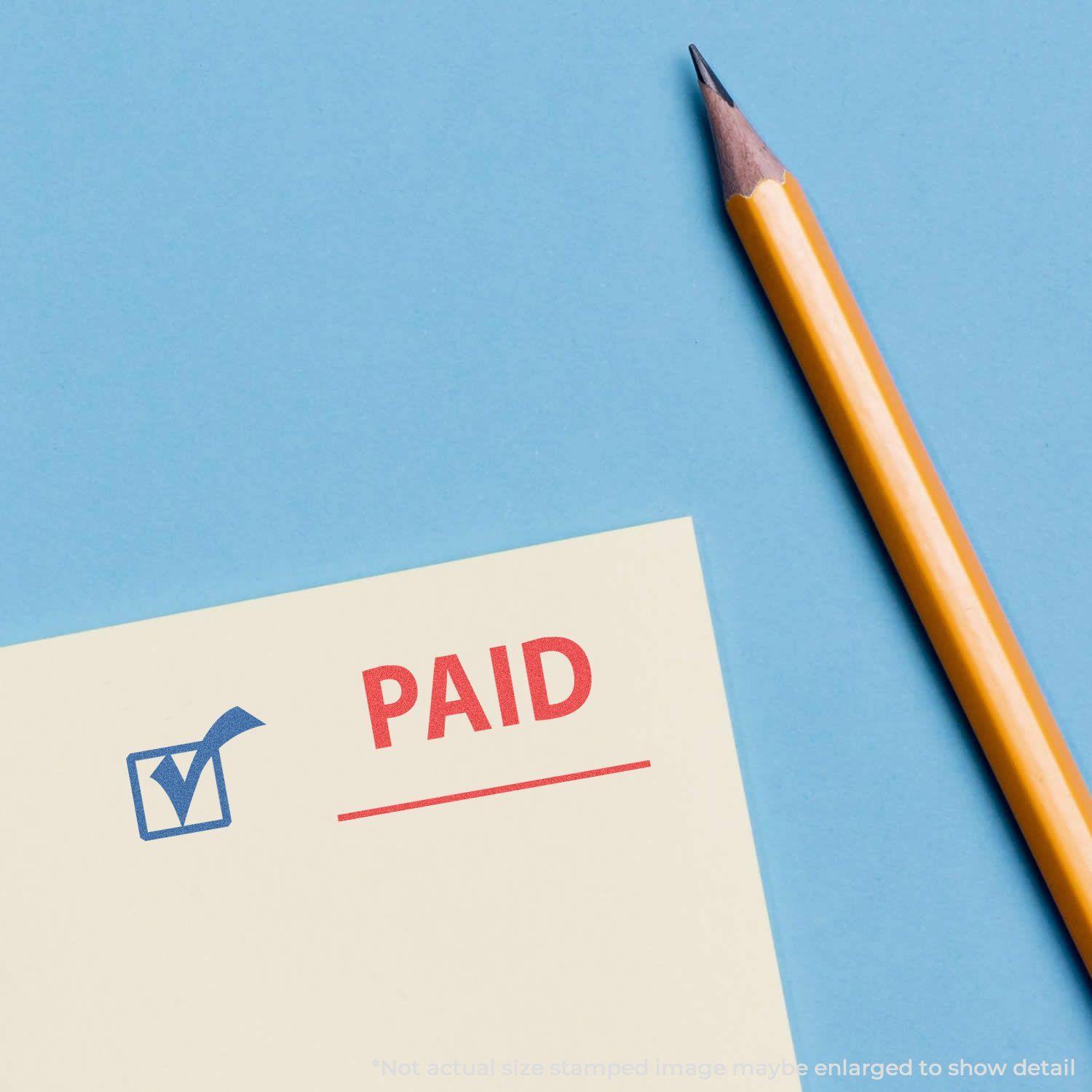 A yellow pencil next to a stamped paper with a blue checkmark and red PAID using the Two-Color Paid Xstamper Stamp on a blue background.