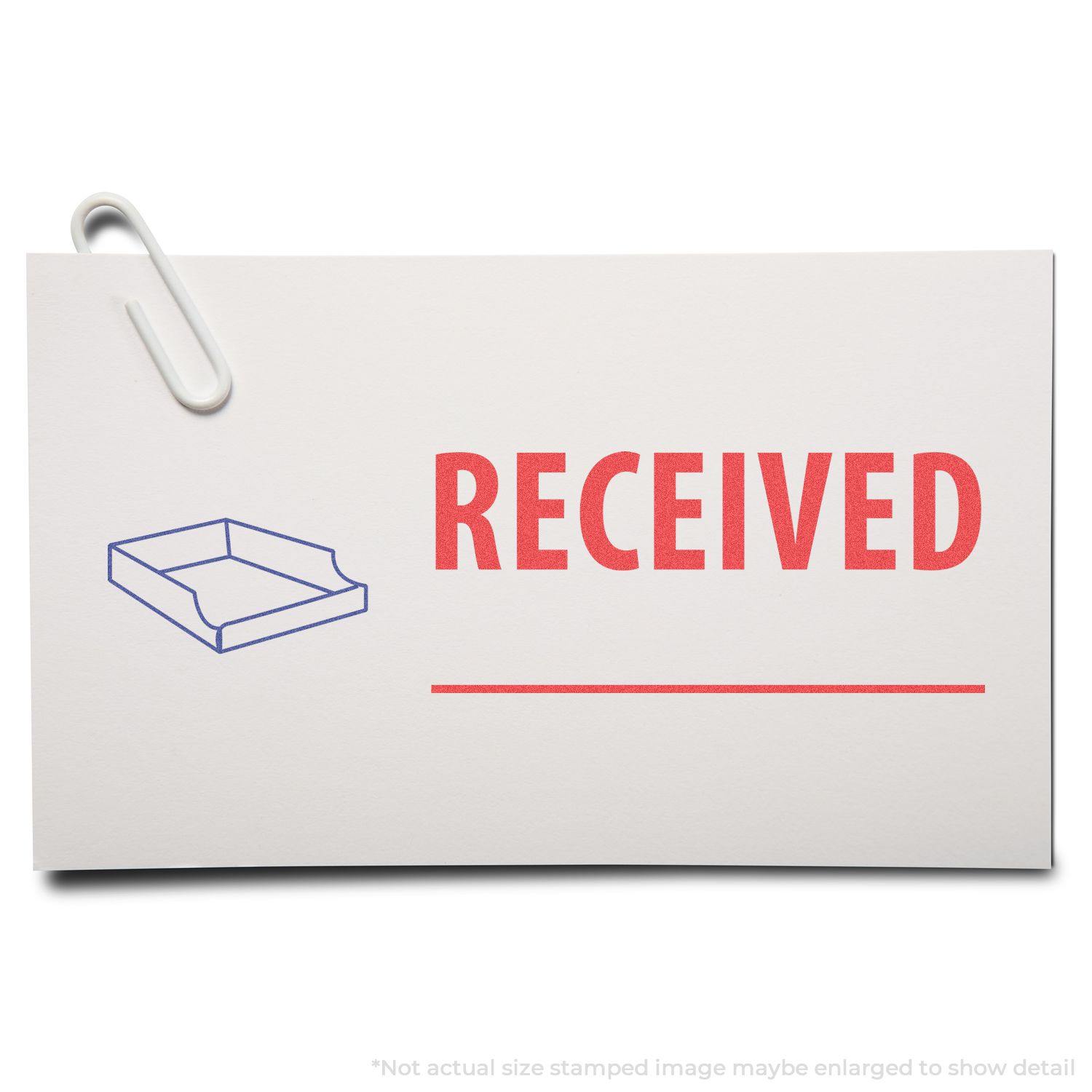 Two-Color Received Xstamper Stamp marking a paper with RECEIVED in red and a blue tray icon, with a paperclip attached to the paper.