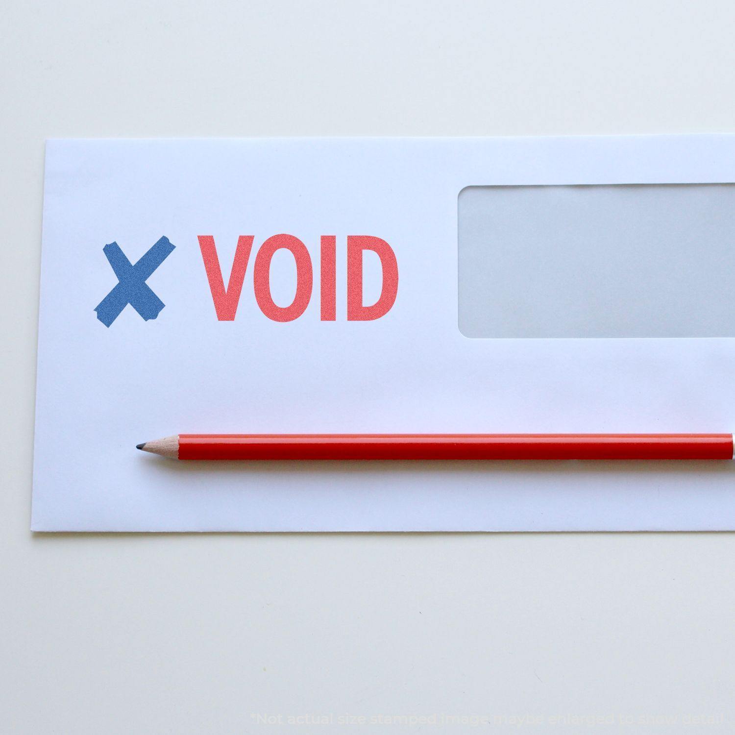 Envelope stamped with a blue X and red VOID using the Two-Color Void Xstamper Stamp, with a red pencil placed below the stamp.
