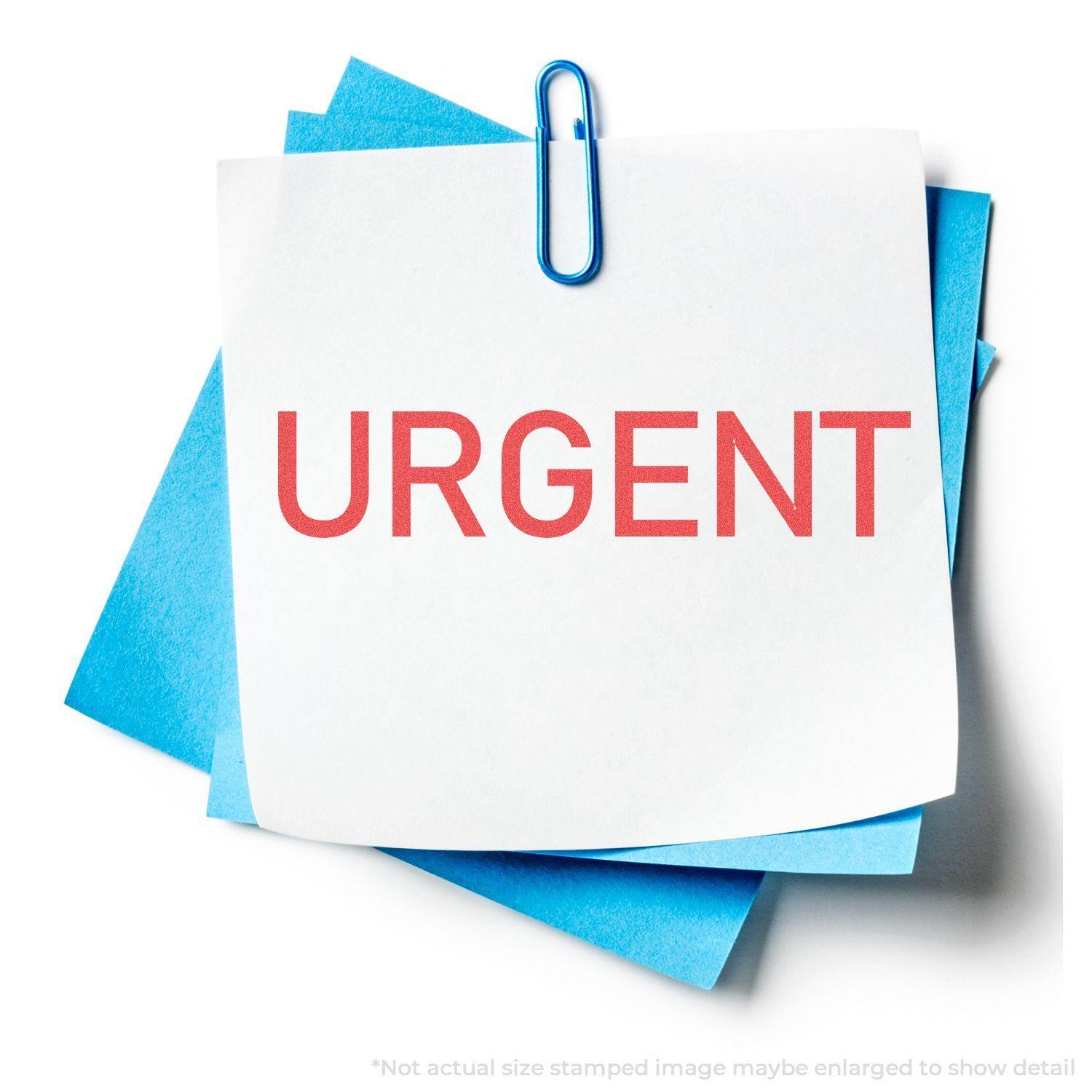 Urgent Xstamper Stamp imprint on white paper with red 'URGENT' text, clipped to blue papers with a blue paperclip.