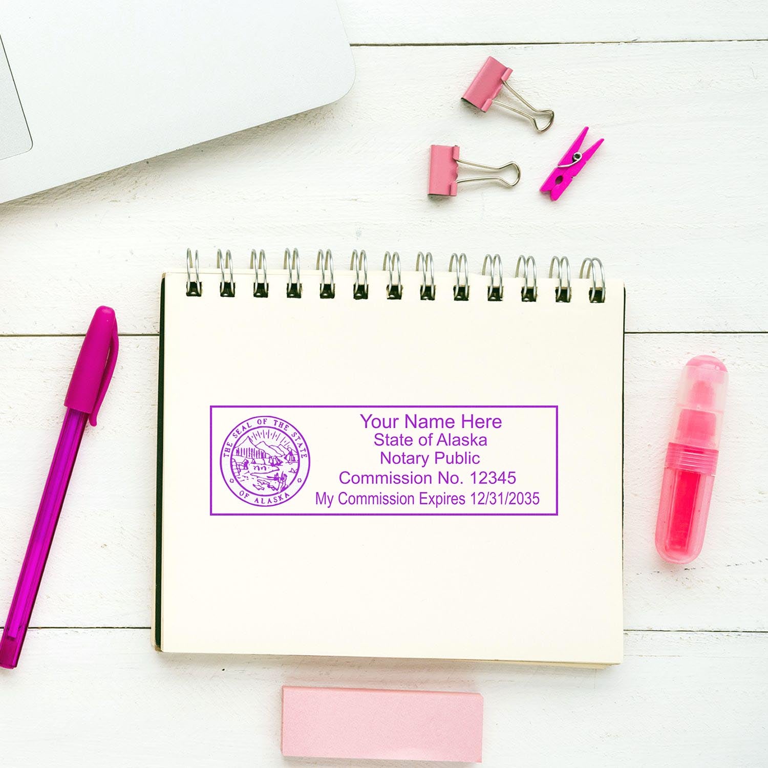 Purple Notary Stamp Feature Image: A notary public stamp from the State of Alaska on a spiral notebook, surrounded by pink office supplies.