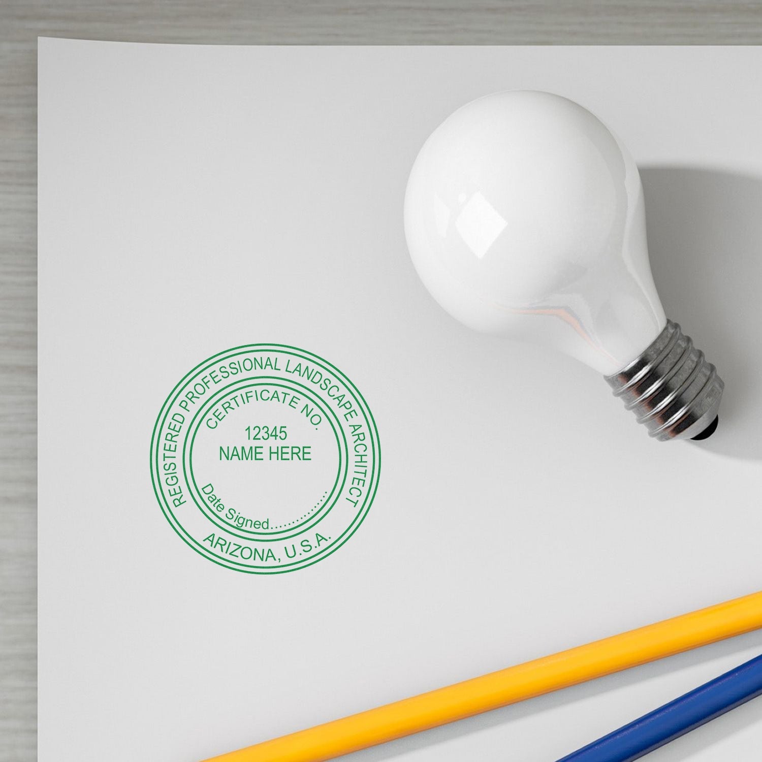 Arizona Landscape Architect Feature Image: A green seal stamp on a white paper with a light bulb and pencils nearby.