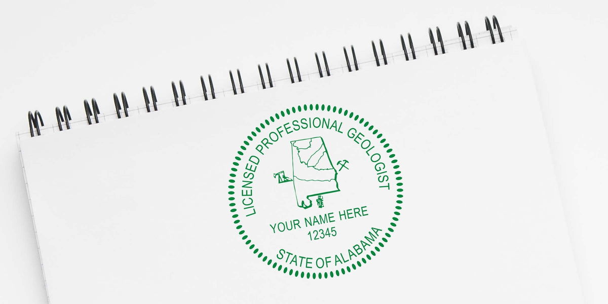 Alabama geologist seal with a state map and mining tools on a white spiral notebook.