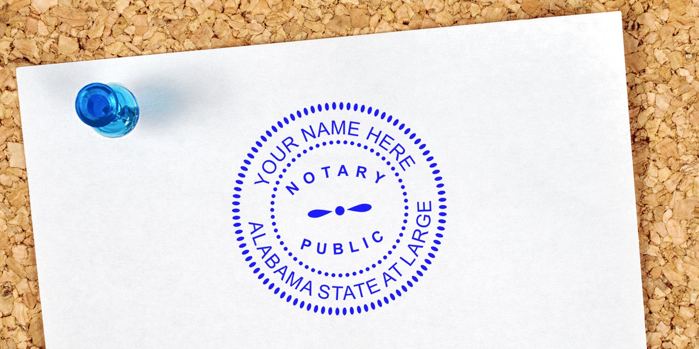 Blue circular "Notary Public" stamp mockup reading "Your Name Here, Alabama State At Large" on white paper pinned to corkboard with a blue pushpin