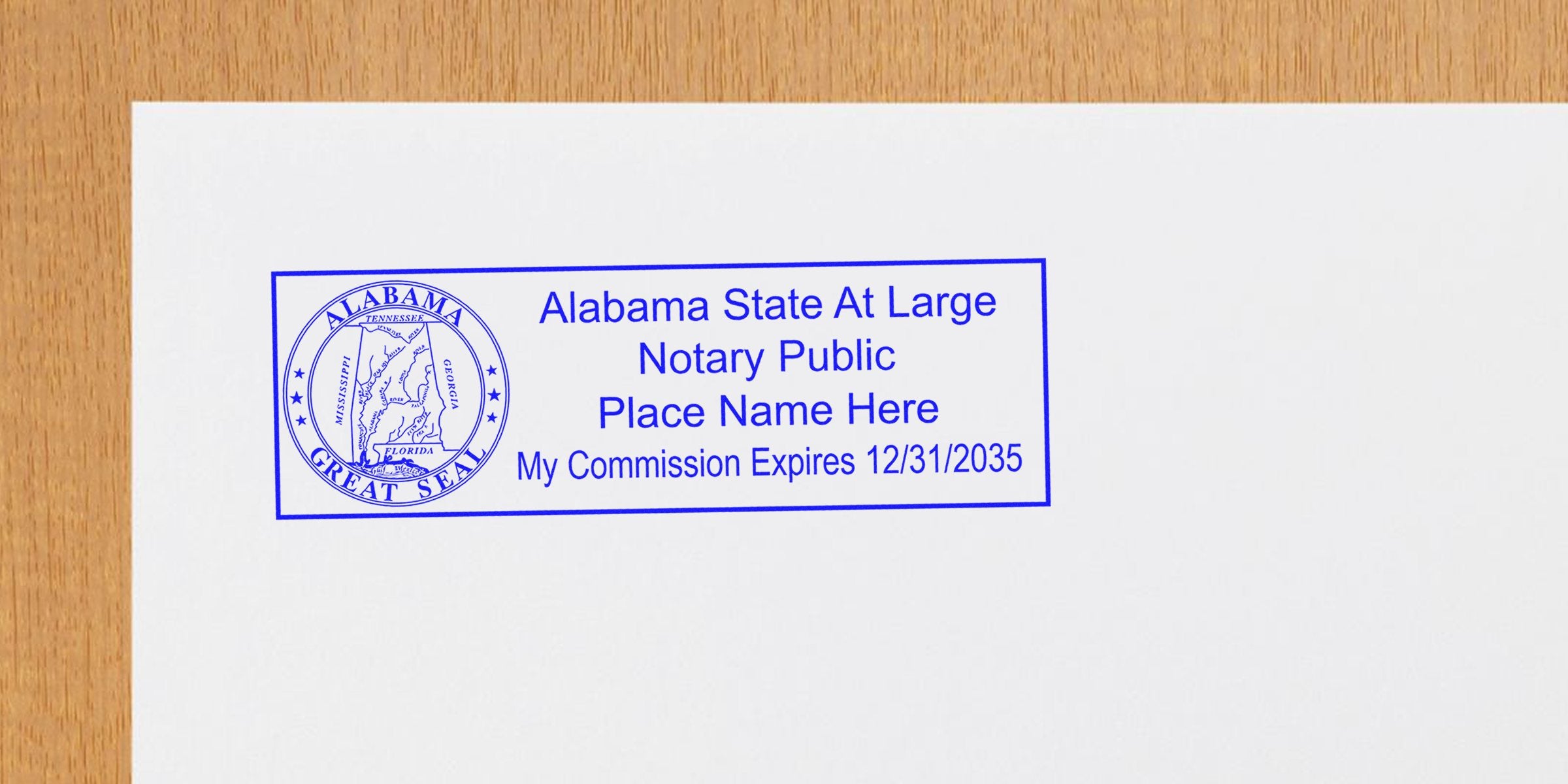 Blue Alabama State at Large notary public stamp with state seal, placeholder name and commission expiration 12/31/2035 on white paper over wood background