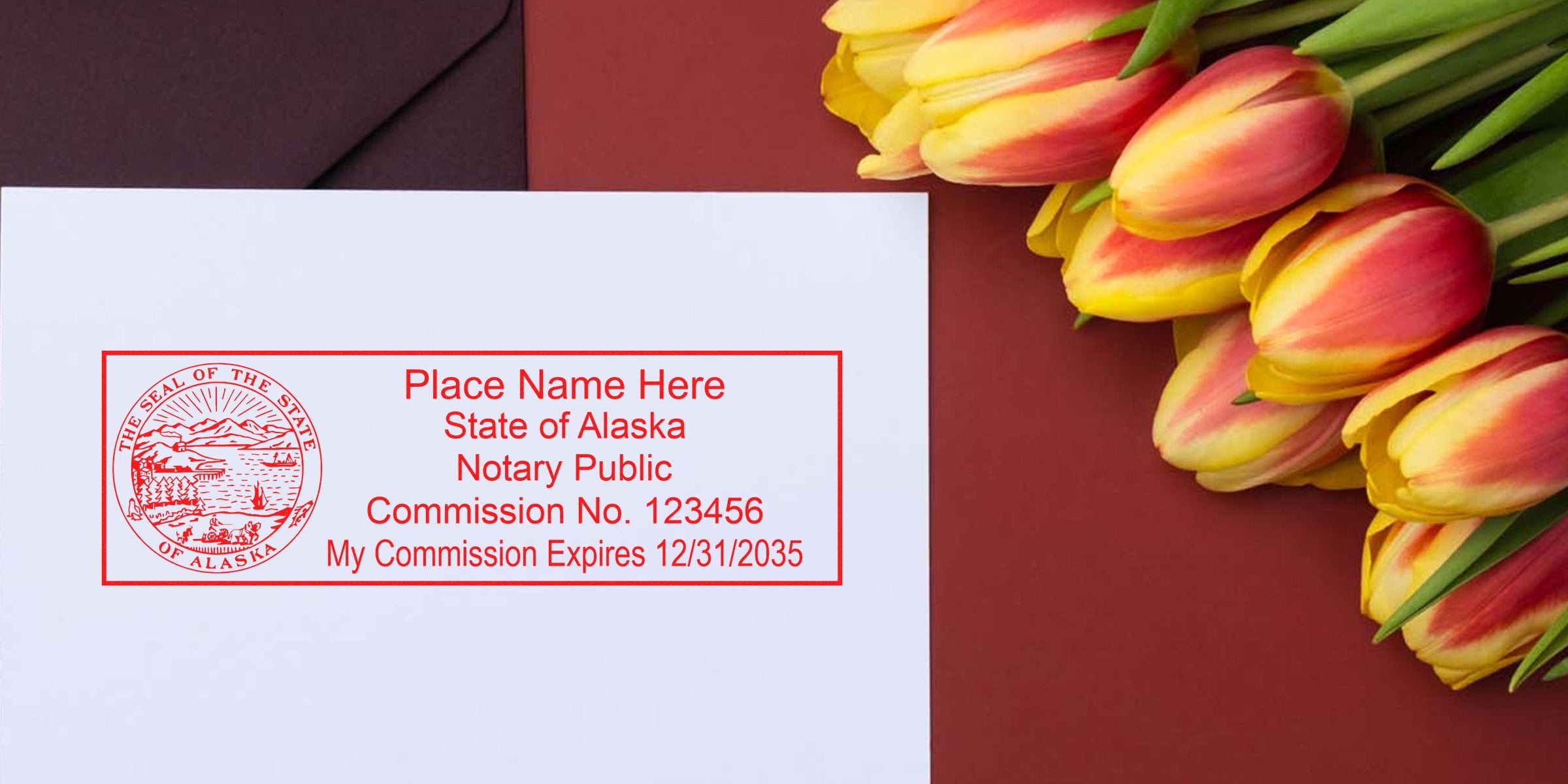 Top-down photo of a white envelope with a red Alaska notary public stamp and placeholder text, beside yellow-red tulips on a maroon background