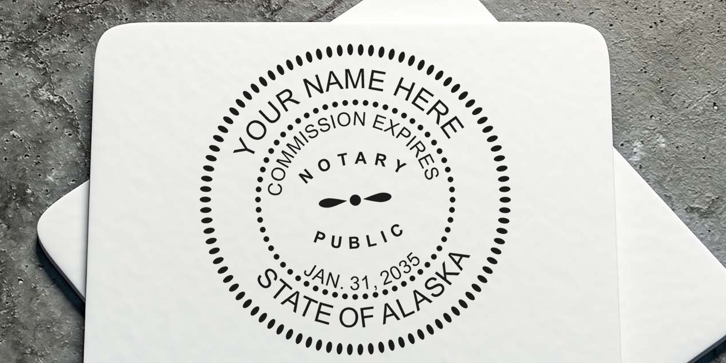 Round black notary public seal stamp on white paper reading "Your Name Here," "State of Alaska," and commission expires Jan. 31, 2035