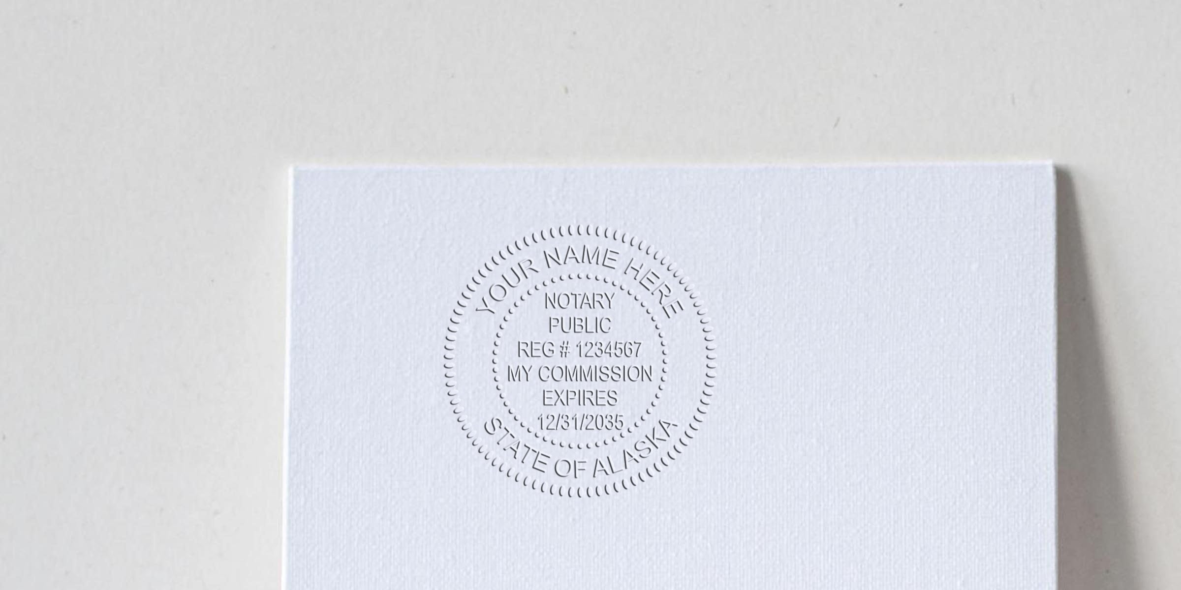 Embossed circular notary public seal on white textured cardstock reading "Your Name Here, Notary Public, Reg #1234567, My Commission Expires 12/31/2035, State of Alaska."