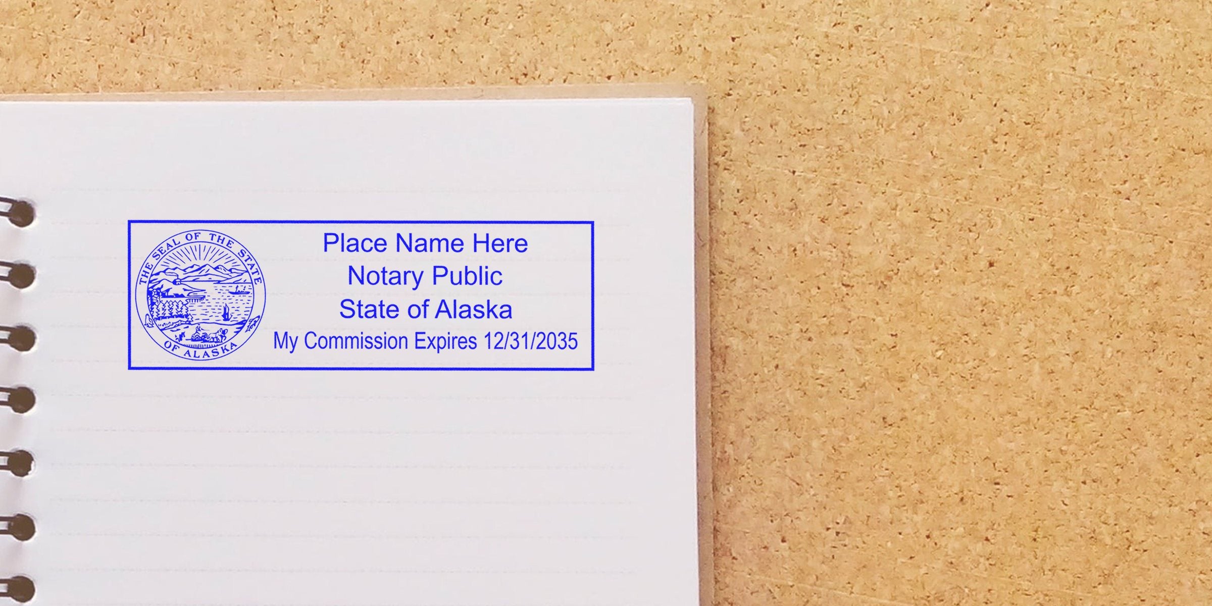 Open spiral notebook on corkboard with blue Alaska notary public stamp reading "Place Name Here, State of Alaska, My Commission Expires 12/31/2035"
