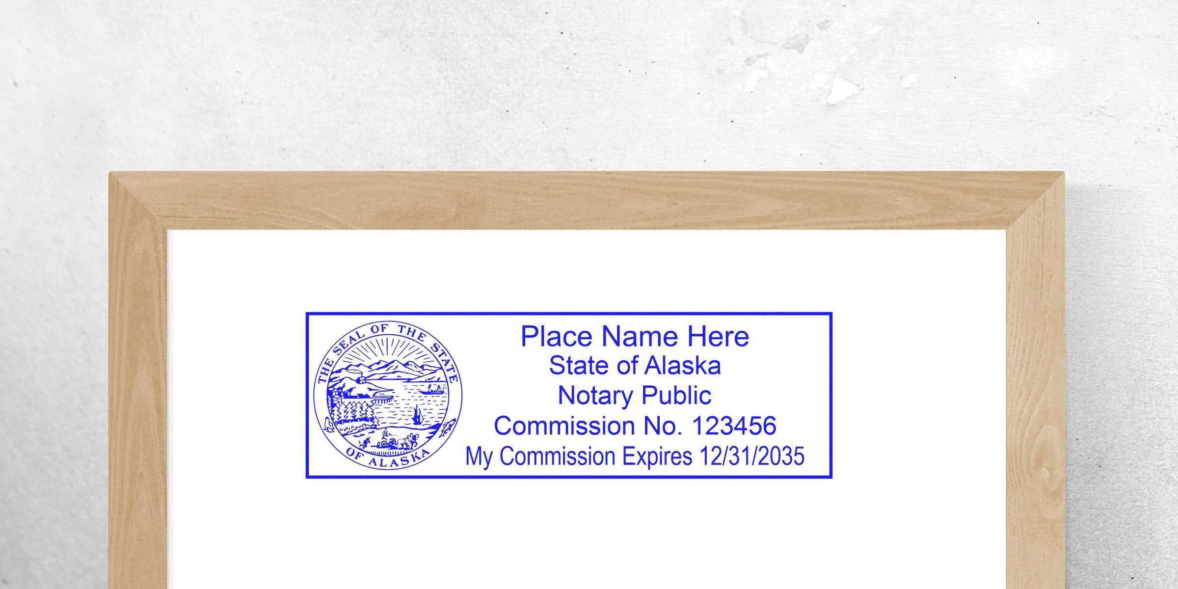 Blue rectangular Alaska notary public stamp template with state seal on left, placeholder "Place Name Here," commission number and expiration date text inside border on white background.