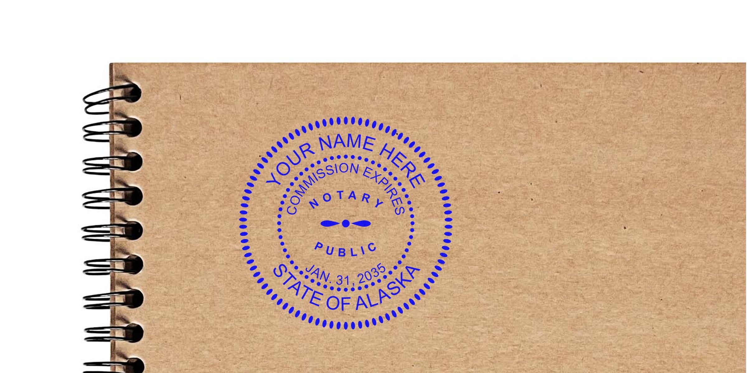 Blue circular notary public stamp reading "State of Alaska" with customizable name and commission expiry, printed in blue on a brown kraft spiral-bound notebook cover