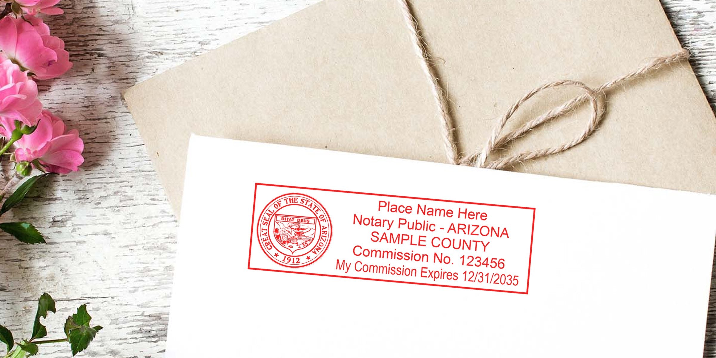 Envelope with red Arizona Notary Public stamp showing sample county and commission info on a white envelope, tied kraft package and pink flowers on rustic white wood background