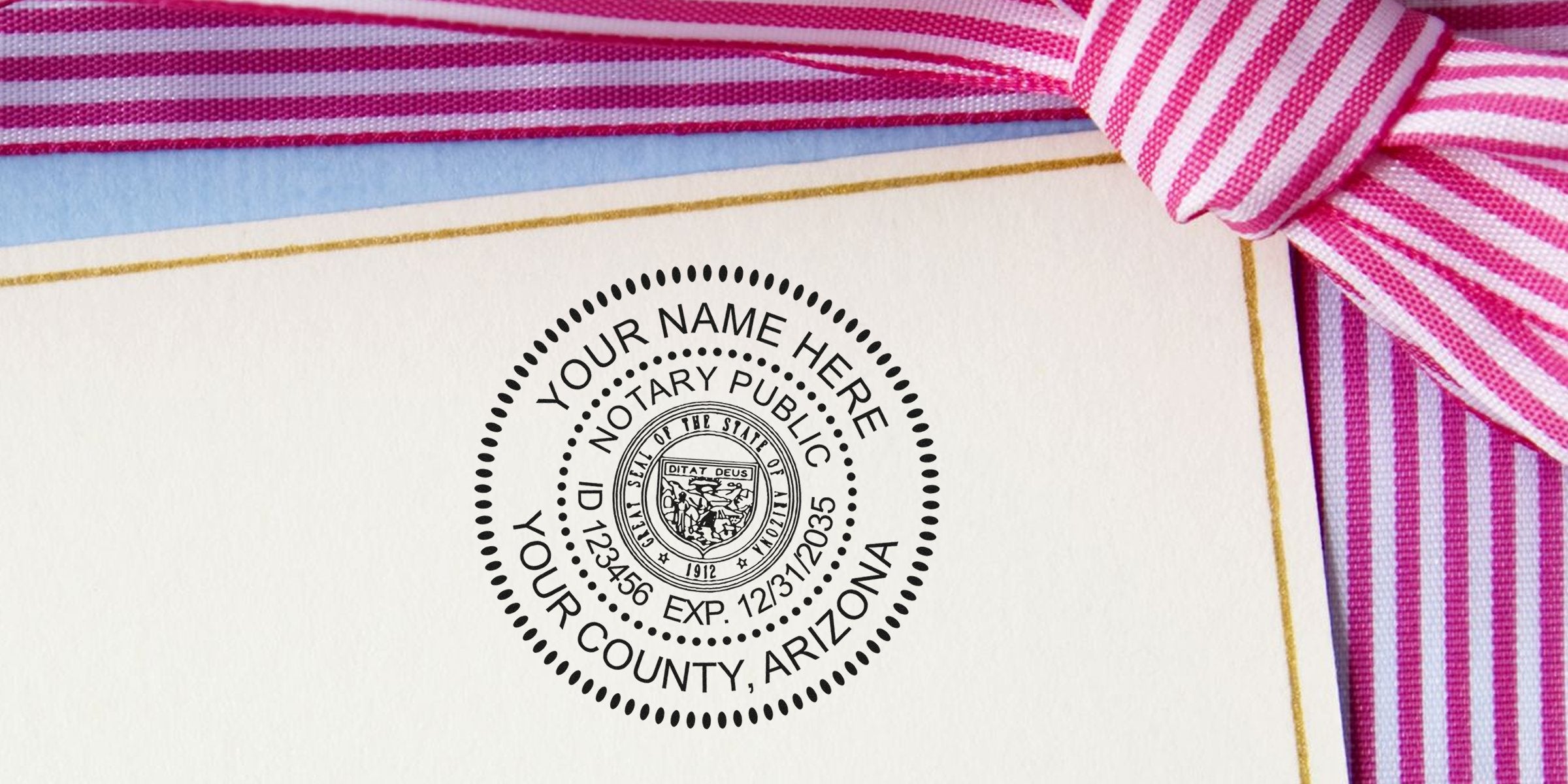 Close-up of a custom notary public seal stamp on cream stationery with gold trim and pink striped ribbon, Arizona county notary ID