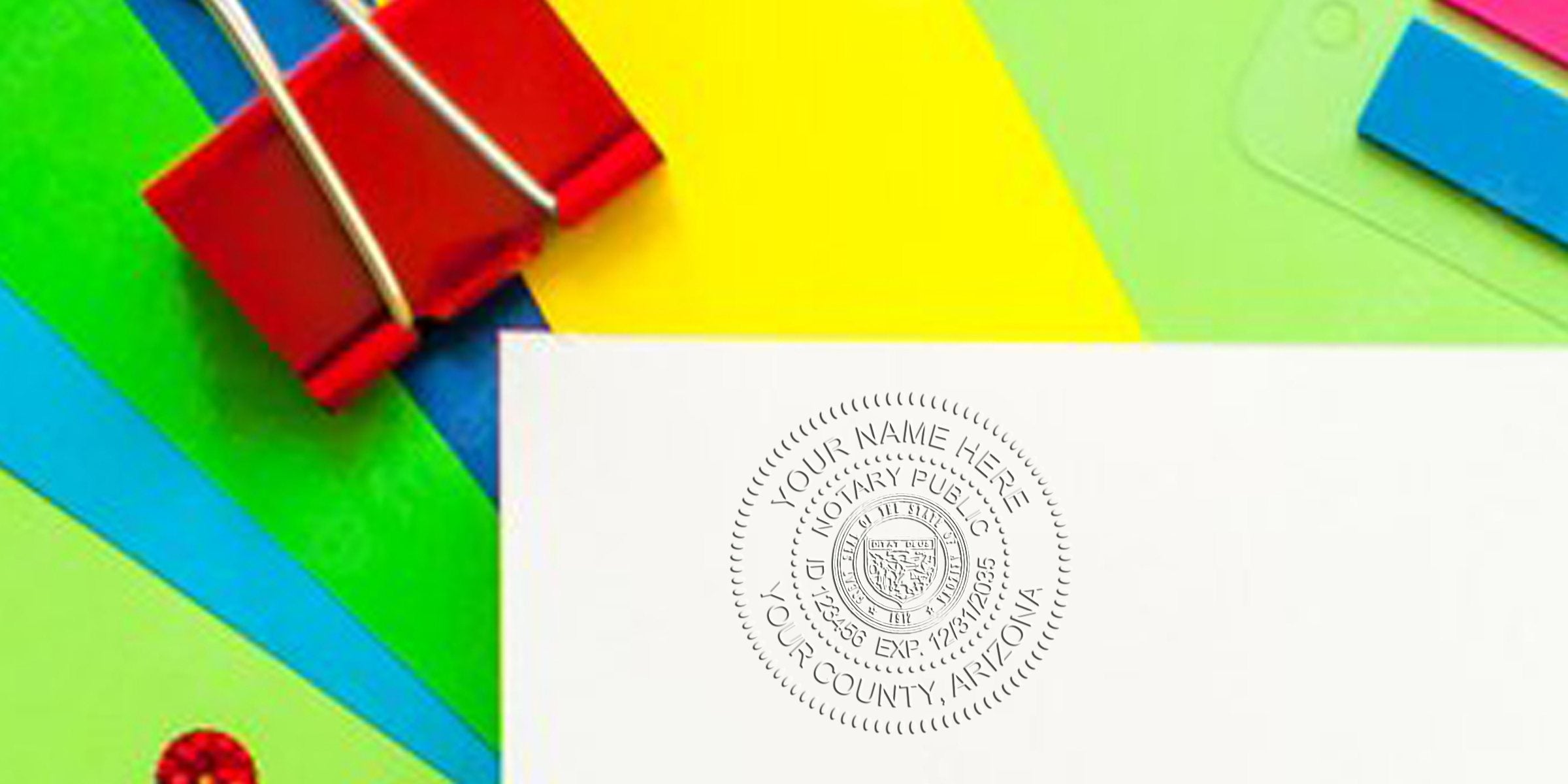 White paper with an embossed notary seal stamp beside a red binder clip on vibrant blue, green and yellow paper background, official document concept