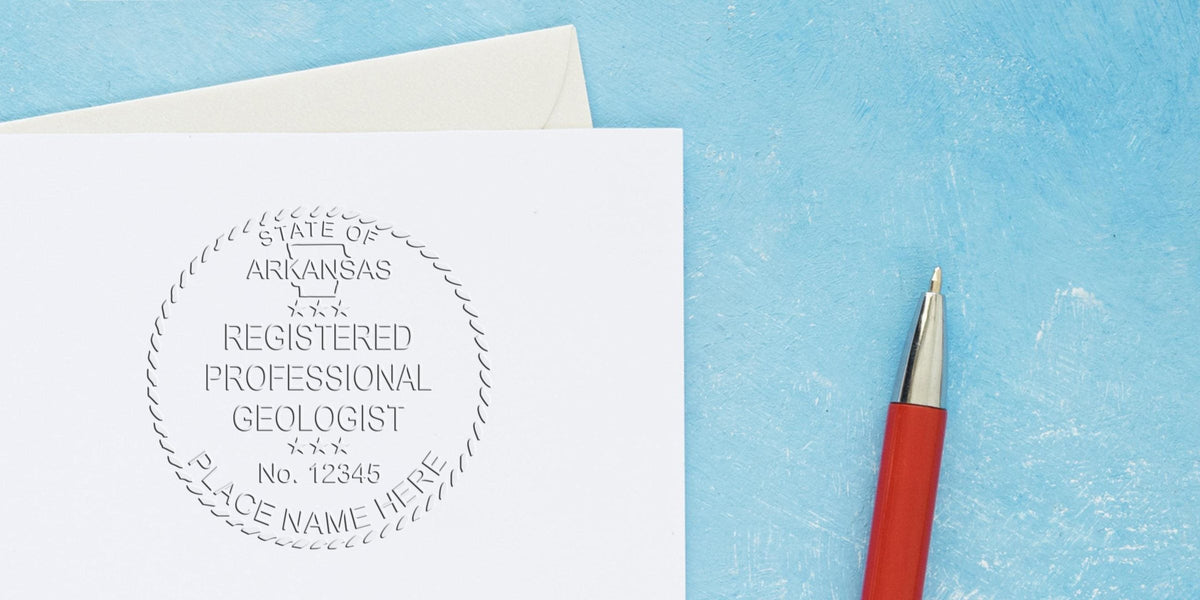 Embossed Arkansas geologist seal on white paper with a red pen on a blue background.
