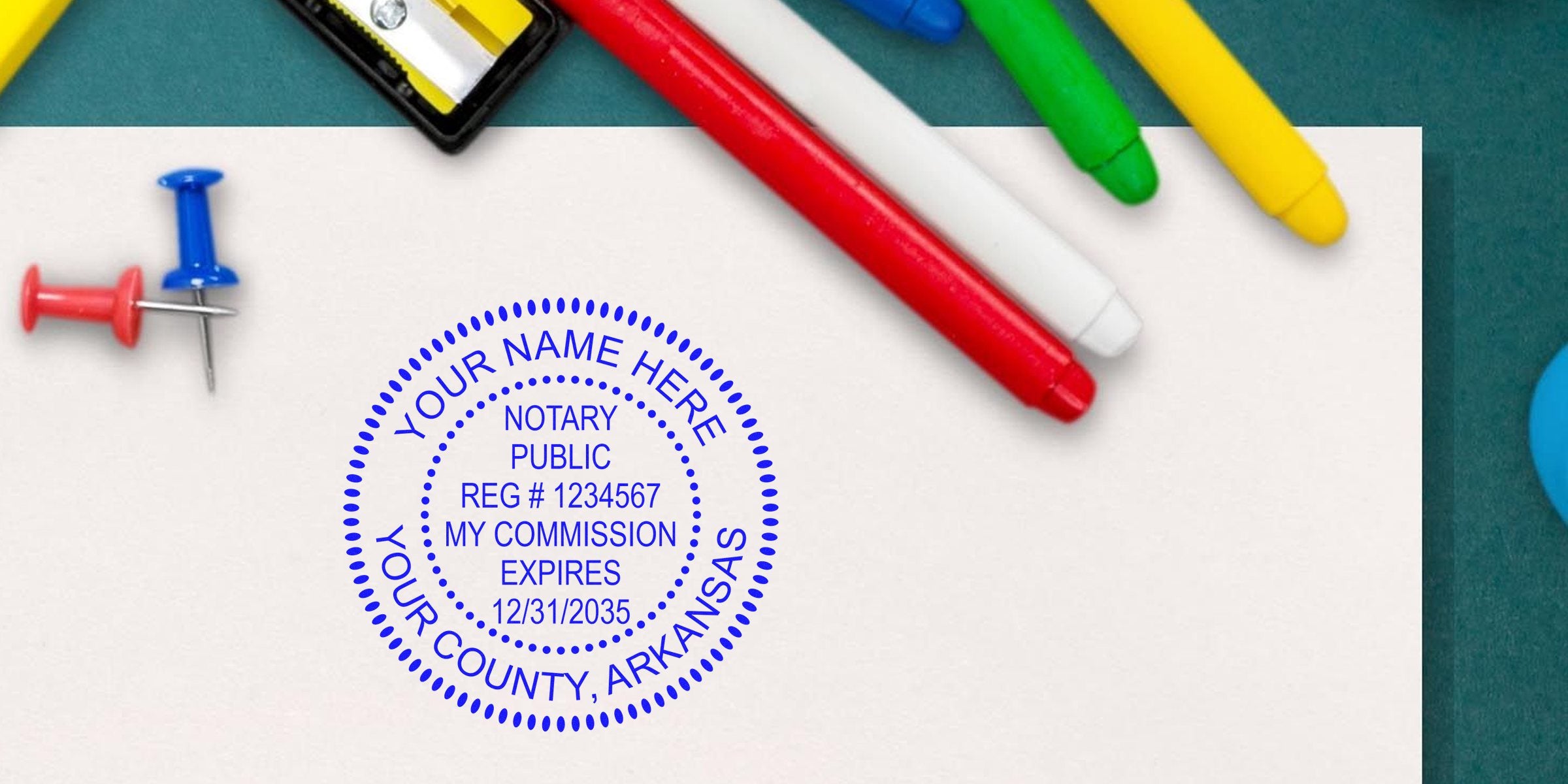 Blue notary public stamp on white paper with colorful markers, push pins and a pencil sharpener on a green desk background