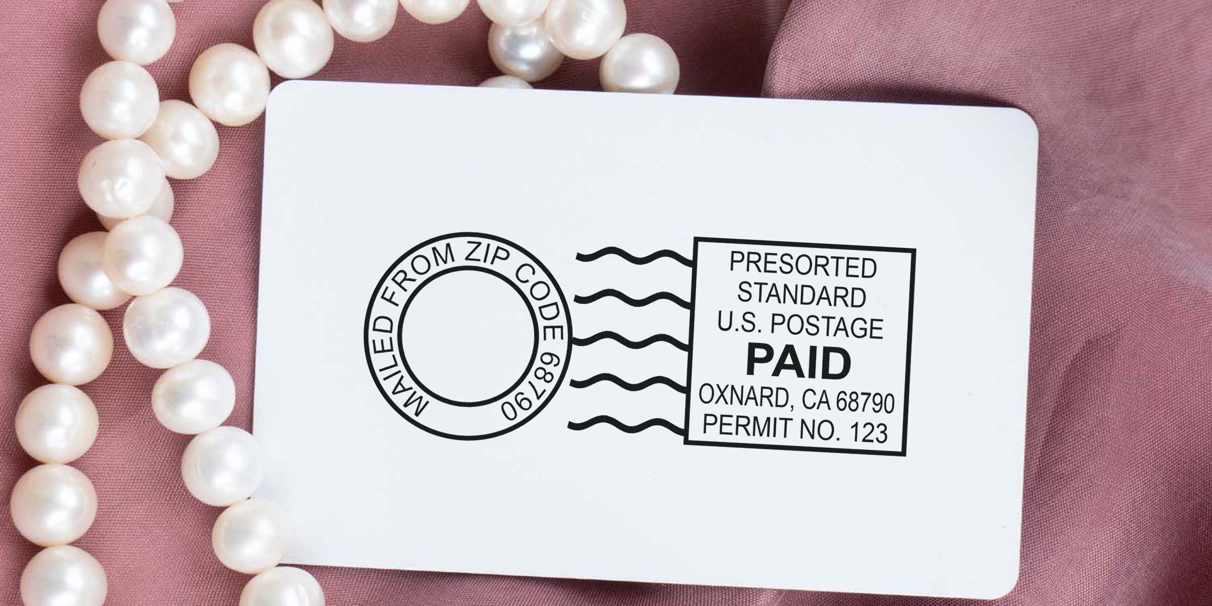 Postcard with a “PAID” postage mark, circular stamp, wavy lines, and pearls on pink fabric.