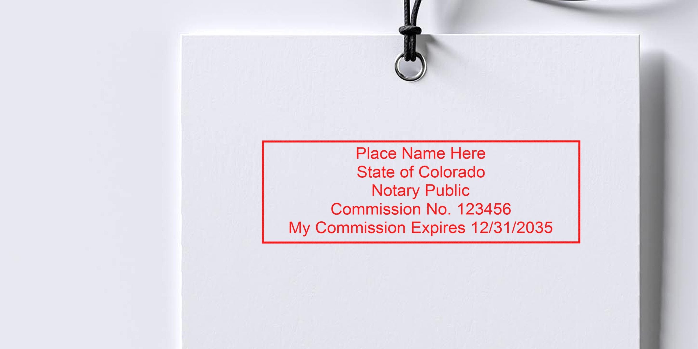 Hanging white ID card with a red rectangular Colorado notary public stamp mockup reading "Place Name Here, State of Colorado, Notary Public, Commission No. 123456, My Commission Expires 12/31/2035"
