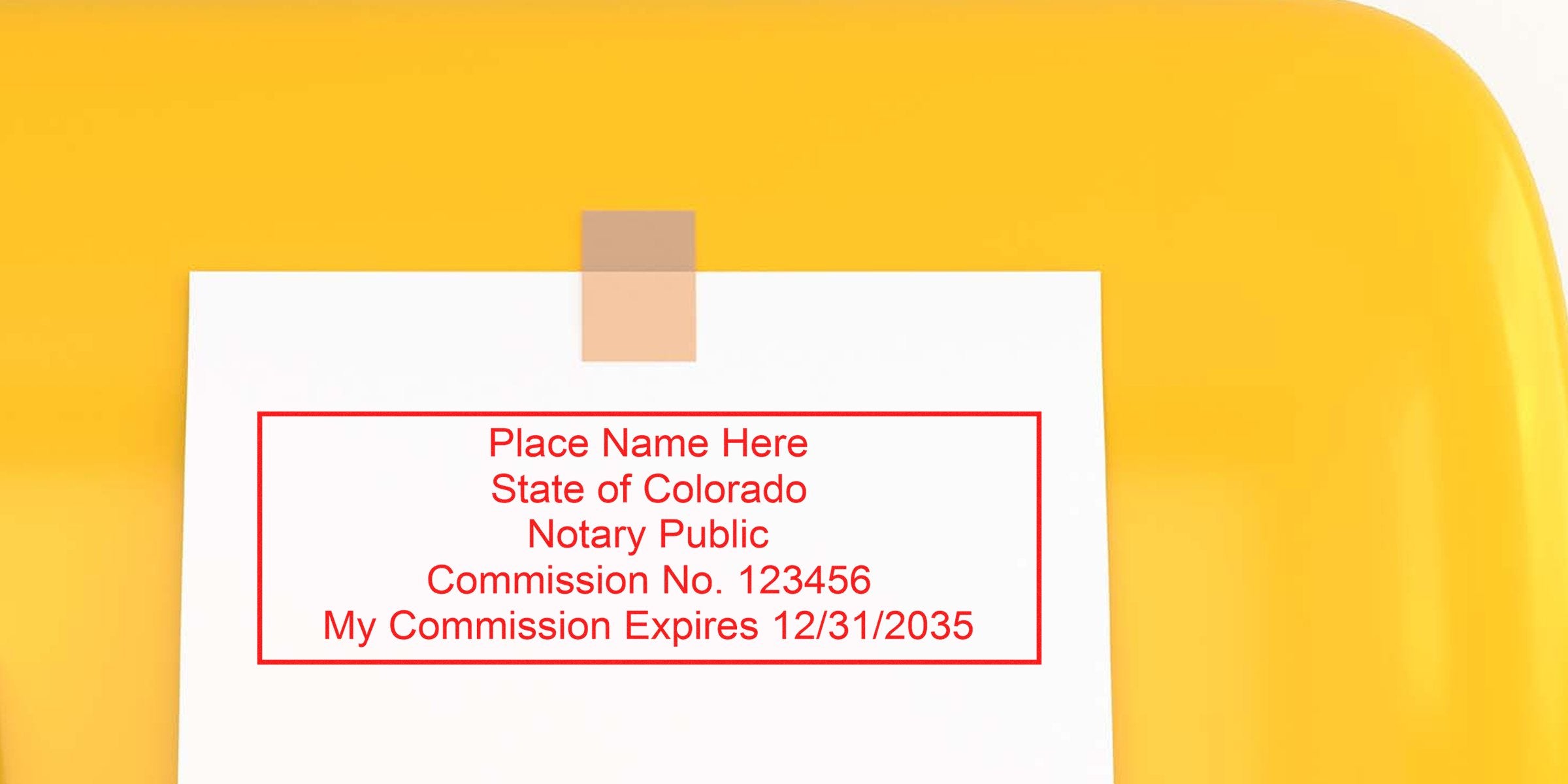 White paper taped to a yellow surface displaying a red notary stamp template: "Place Name Here, State of Colorado, Notary Public, Commission No. 123456, My Commission Expires 12/31/2035."