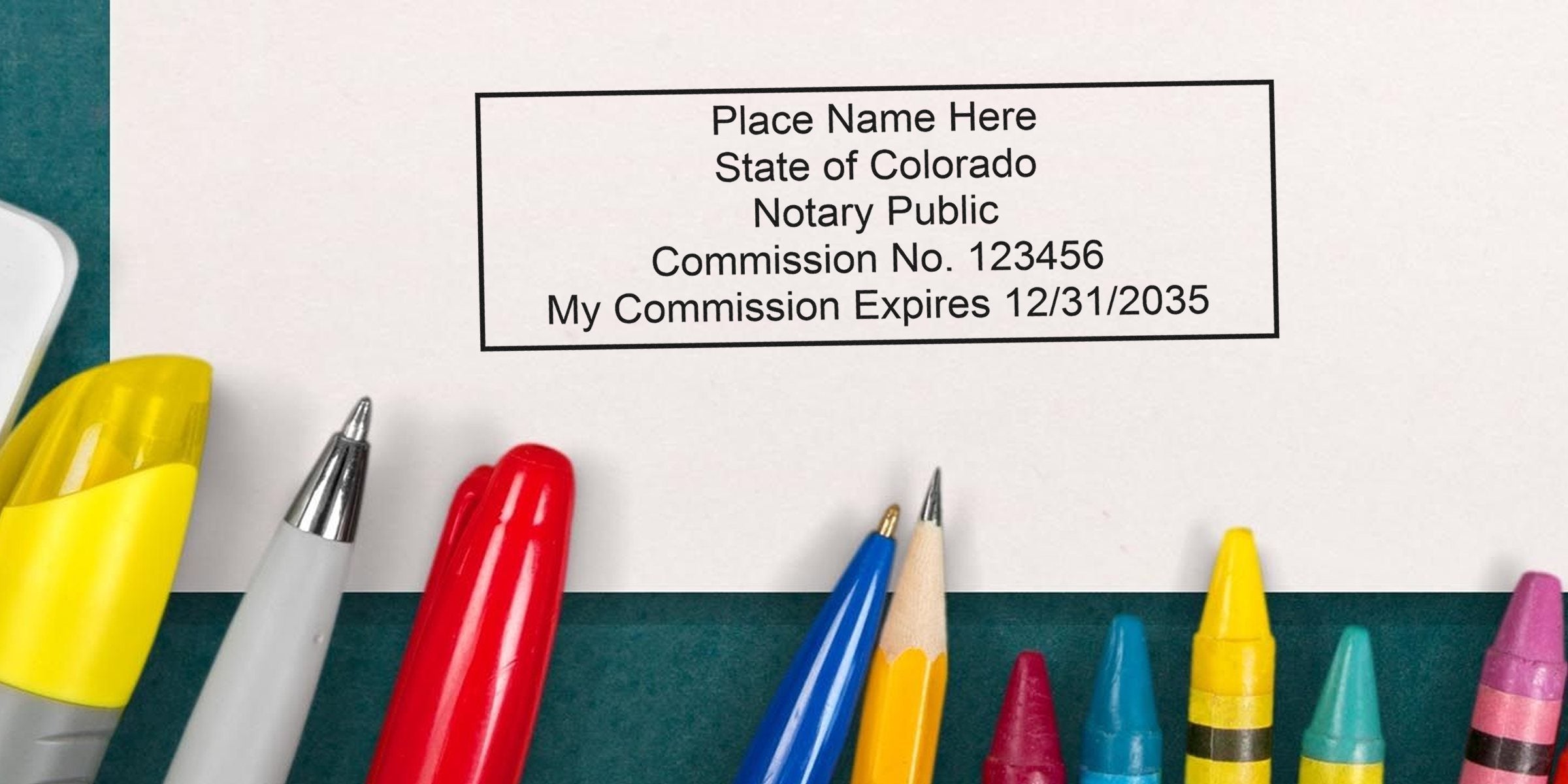 Close-up of a Colorado notary public stamp on paper reading "Commission No. 123456 My Commission Expires 12/31/2035" with colorful pens, pencil and crayons along the bottom.