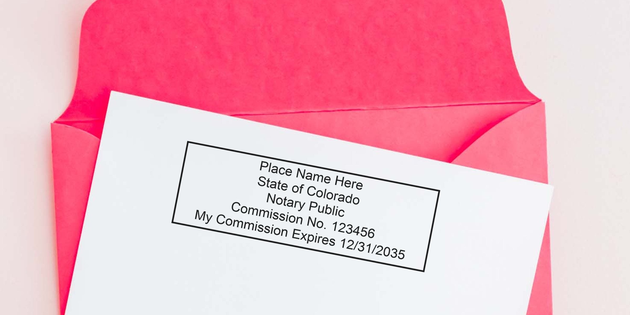 Pink envelope with white document showing a rectangular Colorado notary public stamp sample reading "Place Name Here, State of Colorado, Notary Public, Commission No. 123456, My Commission Expires 12/31/2035."