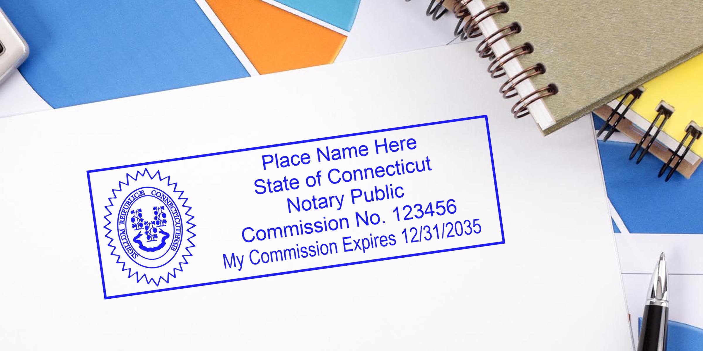 Blue Connecticut notary public stamp template on white paper showing seal, sample commission number and expiration date, with pen and spiral notebooks nearby