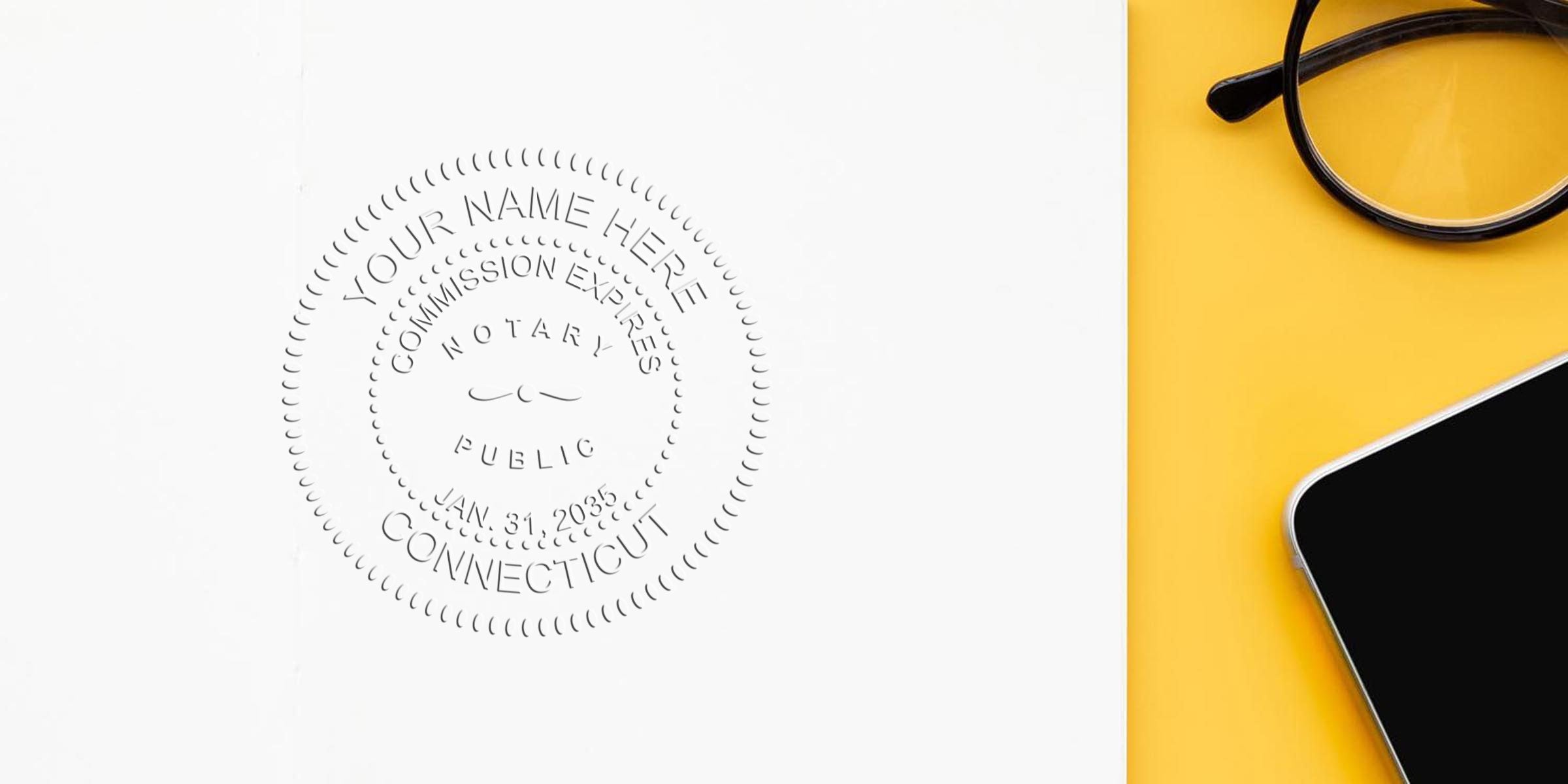 Embossed notary public seal on white paper reading "Connecticut" beside black smartphone and round glasses on a yellow desk surface