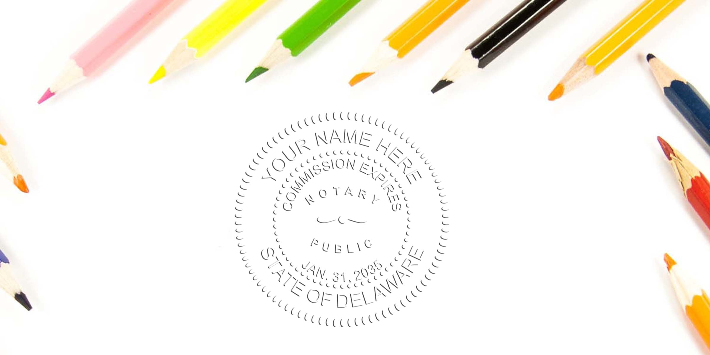 Top-down view of colorful sharpened pencils framing a blank white sheet with a faint embossed notary public seal reading "State of Delaware" — concept image for stationery, notary services, education and office supplies