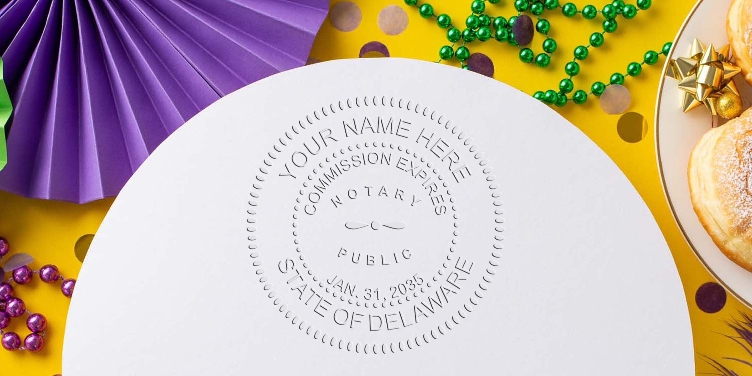 Close-up of embossed notary public seal on white paper reading "STATE OF DELAWARE" with green and purple Mardi Gras beads, purple paper rosette and powdered donut on yellow background