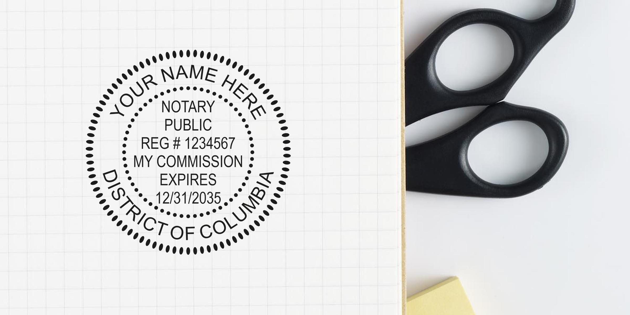 Notary public rubber stamp mockup on grid paper with customizable name, registration number and commission expiry, photographed next to black scissors and a yellow sticky note for office stationery concept