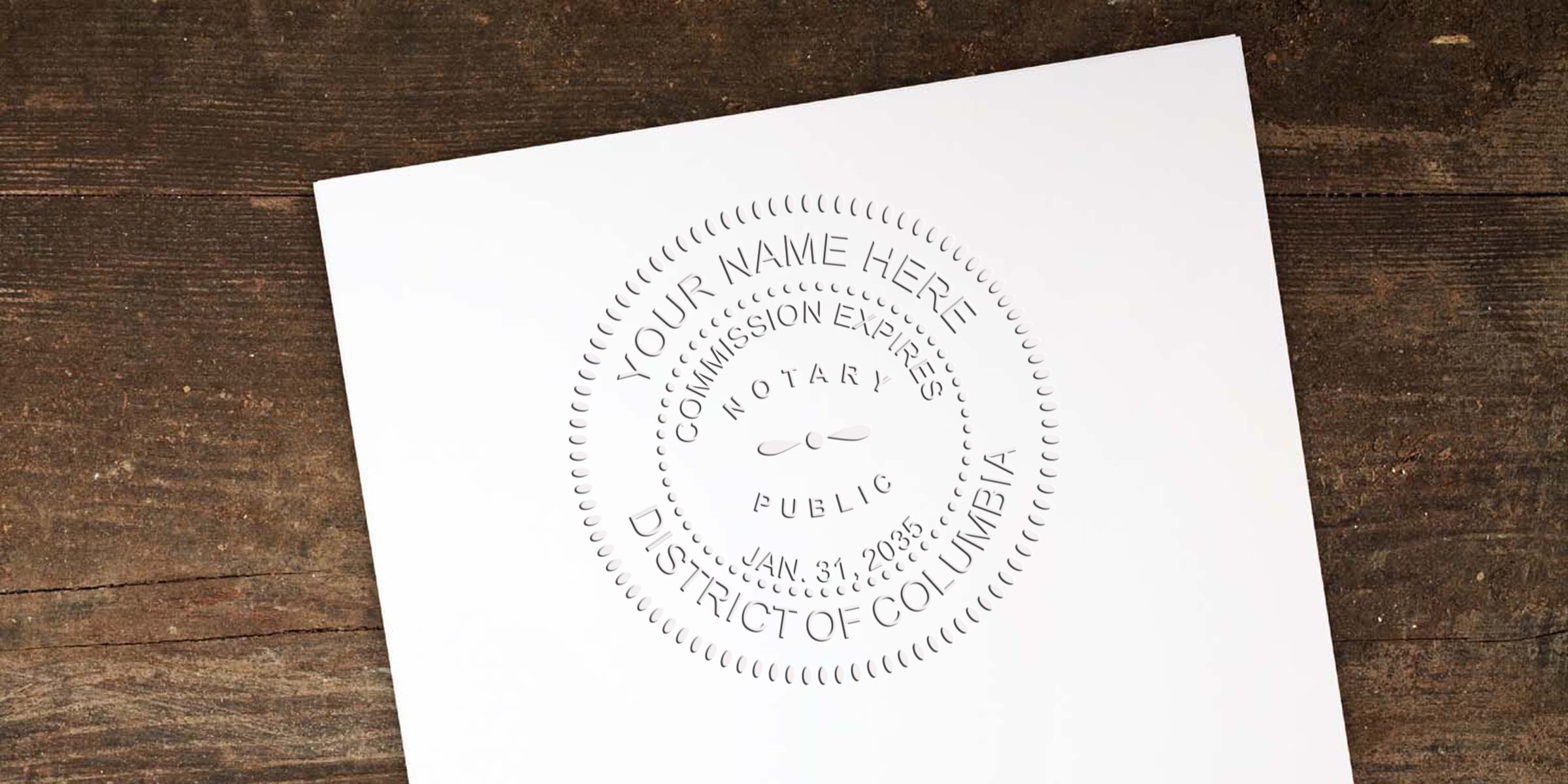 White paper with an embossed circular notary public seal reading "Your Name Here, Commission Expires, District of Columbia" placed on rustic wooden surface, angled slightly to the left.
