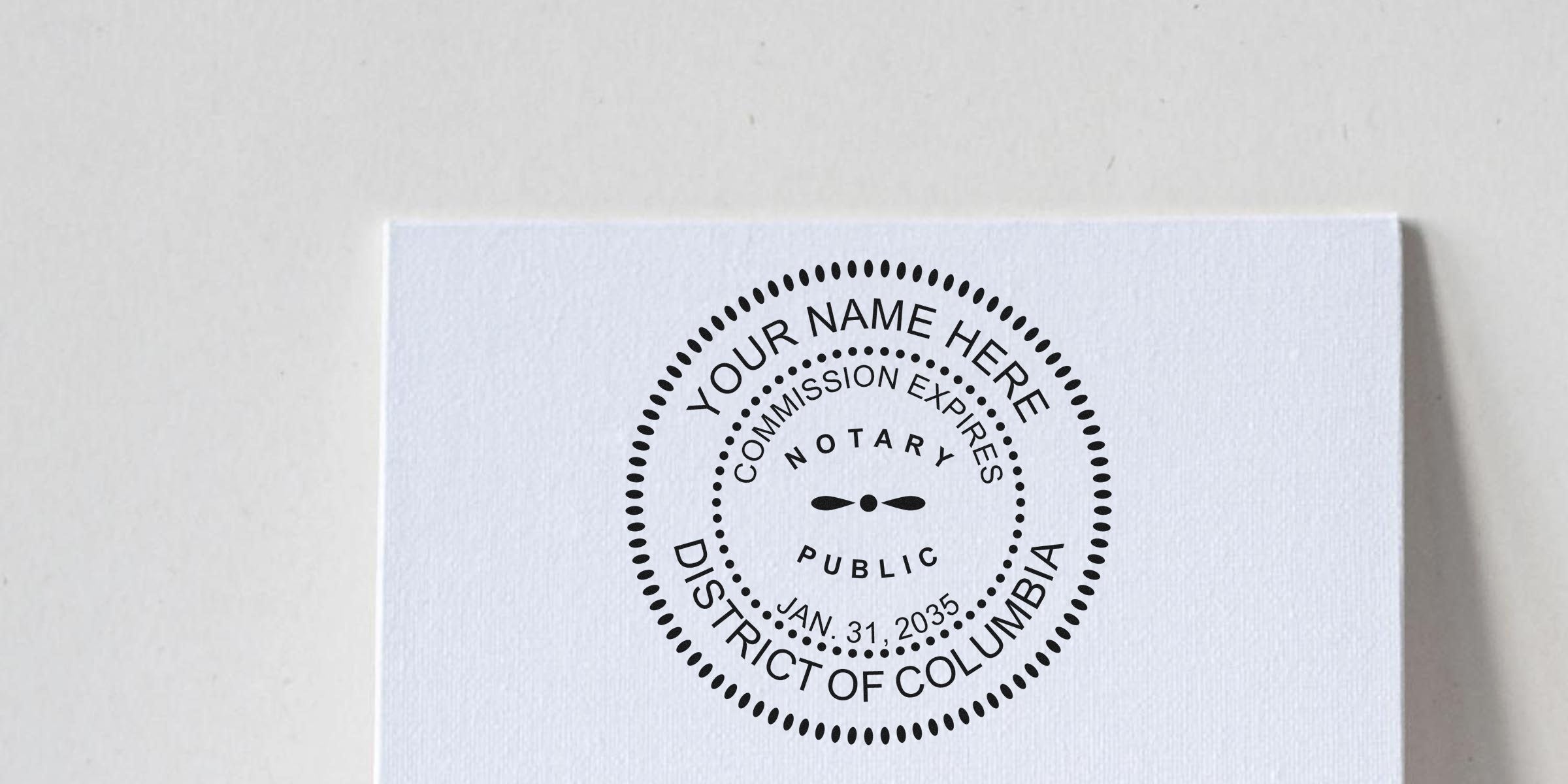 Black circular District of Columbia notary public seal stamp on white textured paper reading "Your Name Here" and "Commission Expires Jan. 31, 2035."