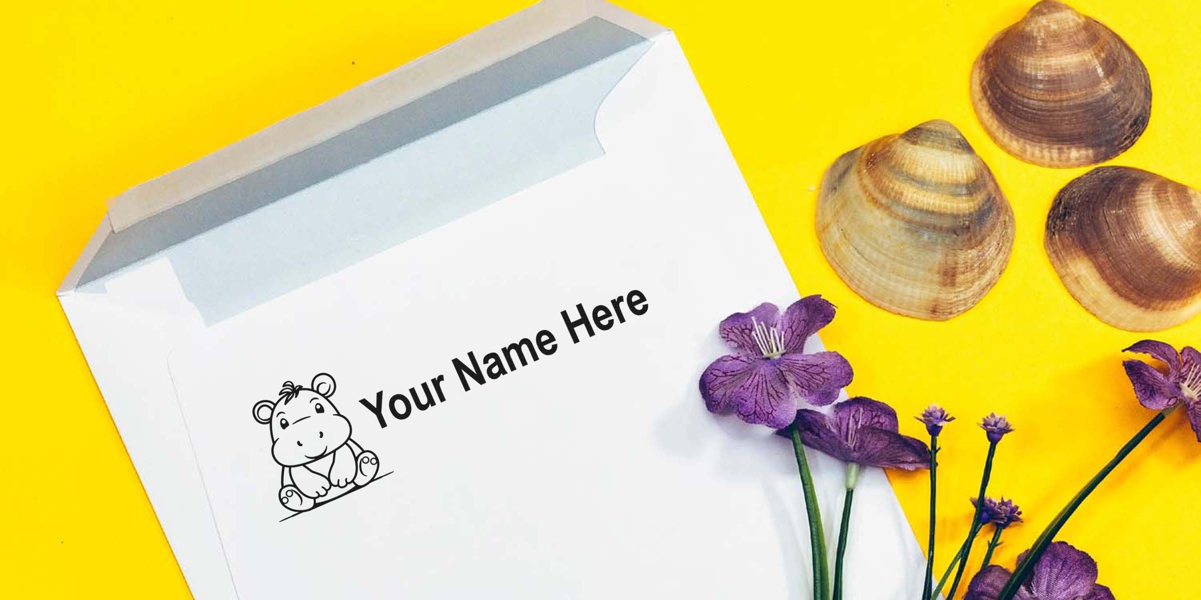 Envelope with the caption “Your Name Here,” featuring a cute hippo illustration, against a bright yellow background with purple flowers and seashells.
