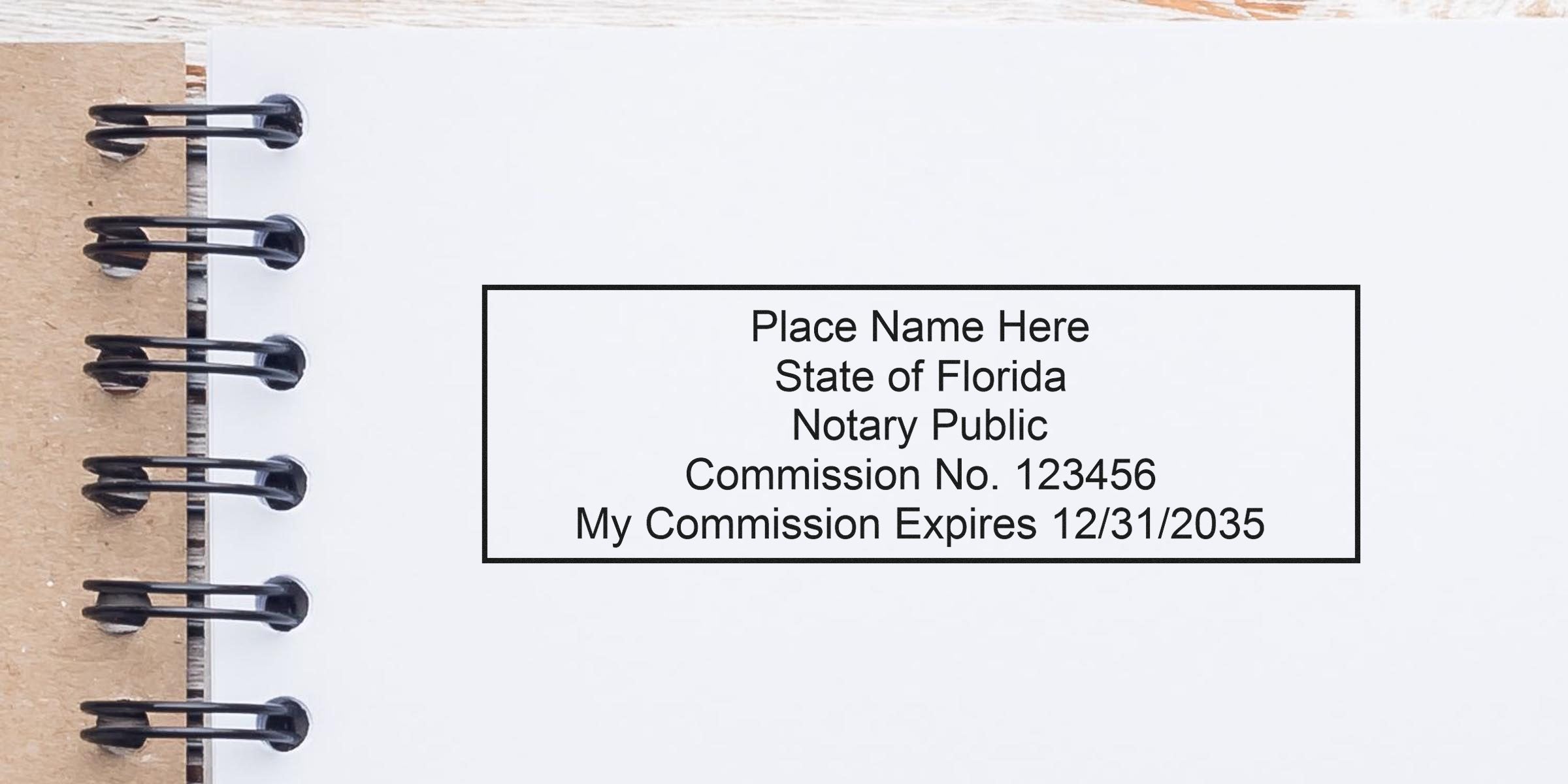 Close-up of spiral notebook page with a black-framed Florida Notary Public stamp mockup reading "Place Name Here, State of Florida, Commission No. 123456, My Commission Expires 12/31/2035"