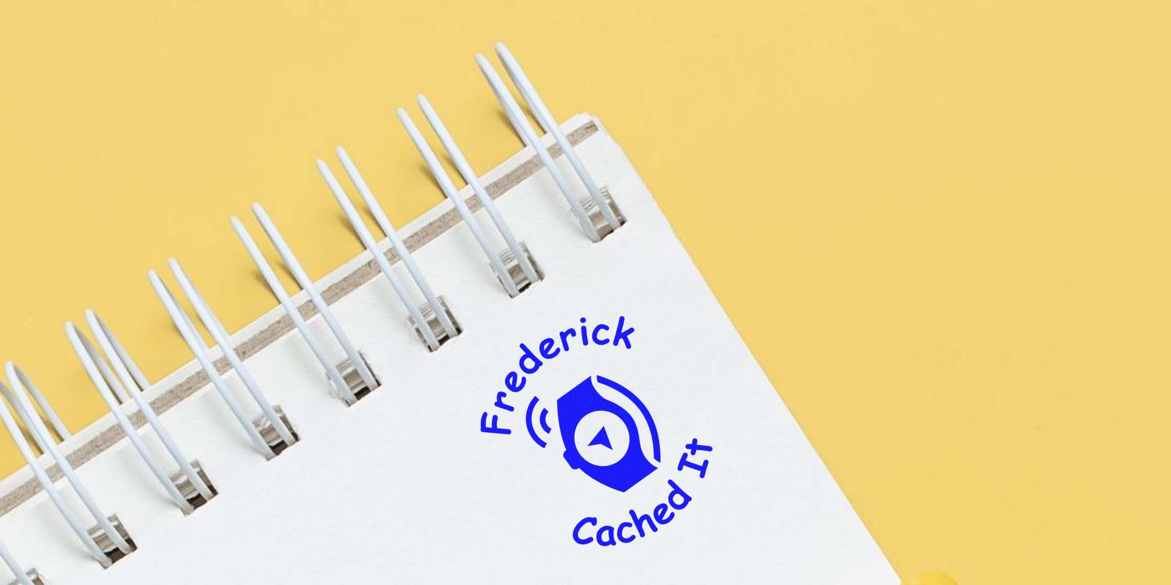Notebook spiral with a blue Frederick Cached It logo on a white page against a yellow background.