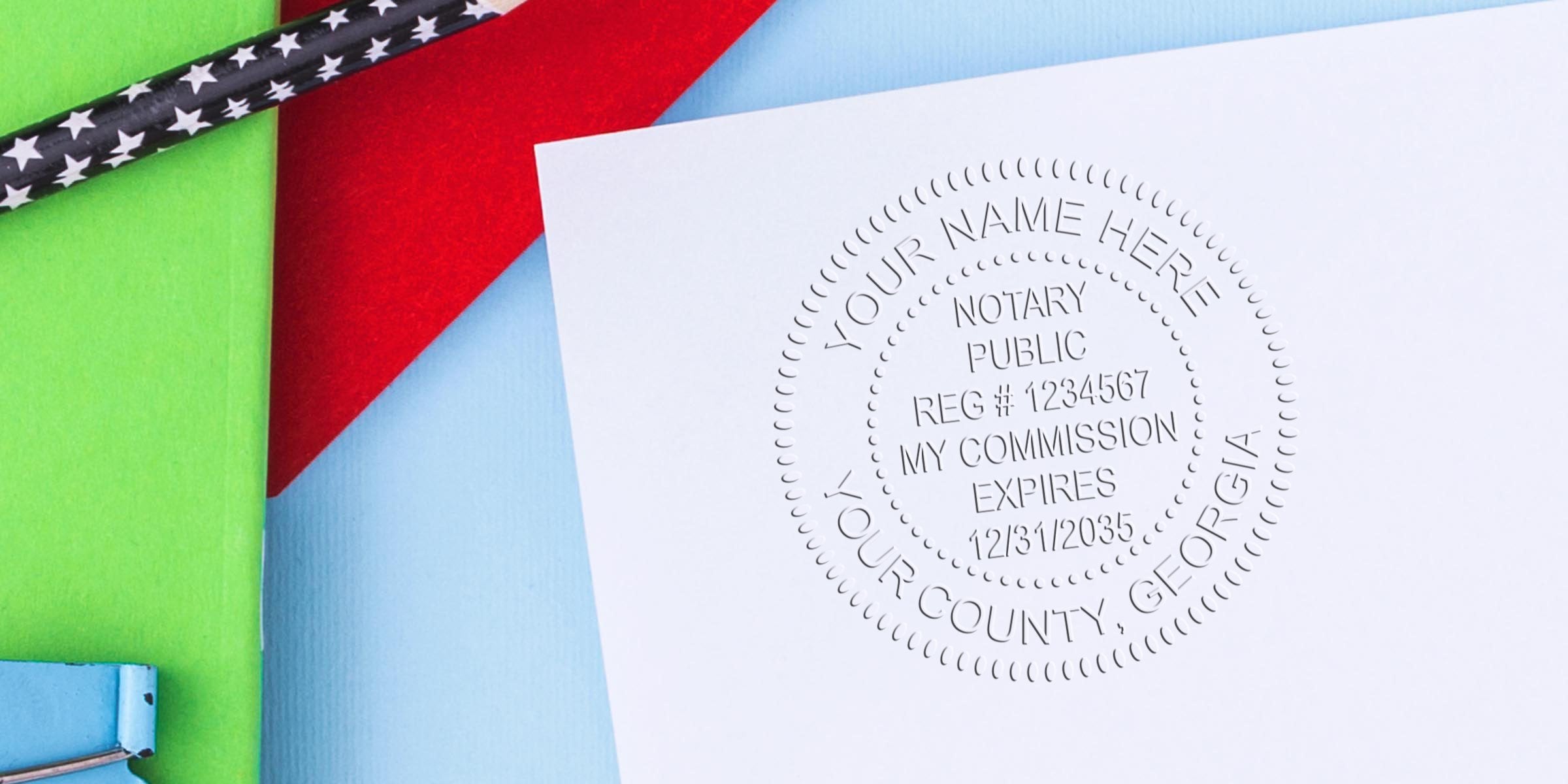 Embossed notary public seal on white paper reading "Notary Public, Reg #1234567, My Commission Expires 12/31/2035, Your County, Georgia" against red, green and blue background with a black star-pattern pencil.