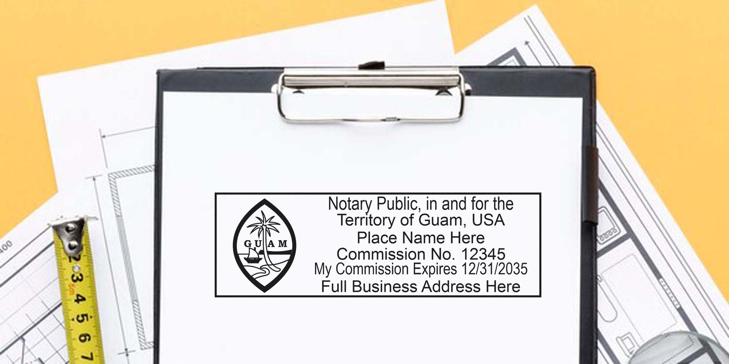 Close-up of a clipboard holding a Guam notary public stamp form on white paper, placed over architectural plans with a yellow measuring tape and pen nearby — Guam notary stamp, commission details, office paperwork, construction documents.