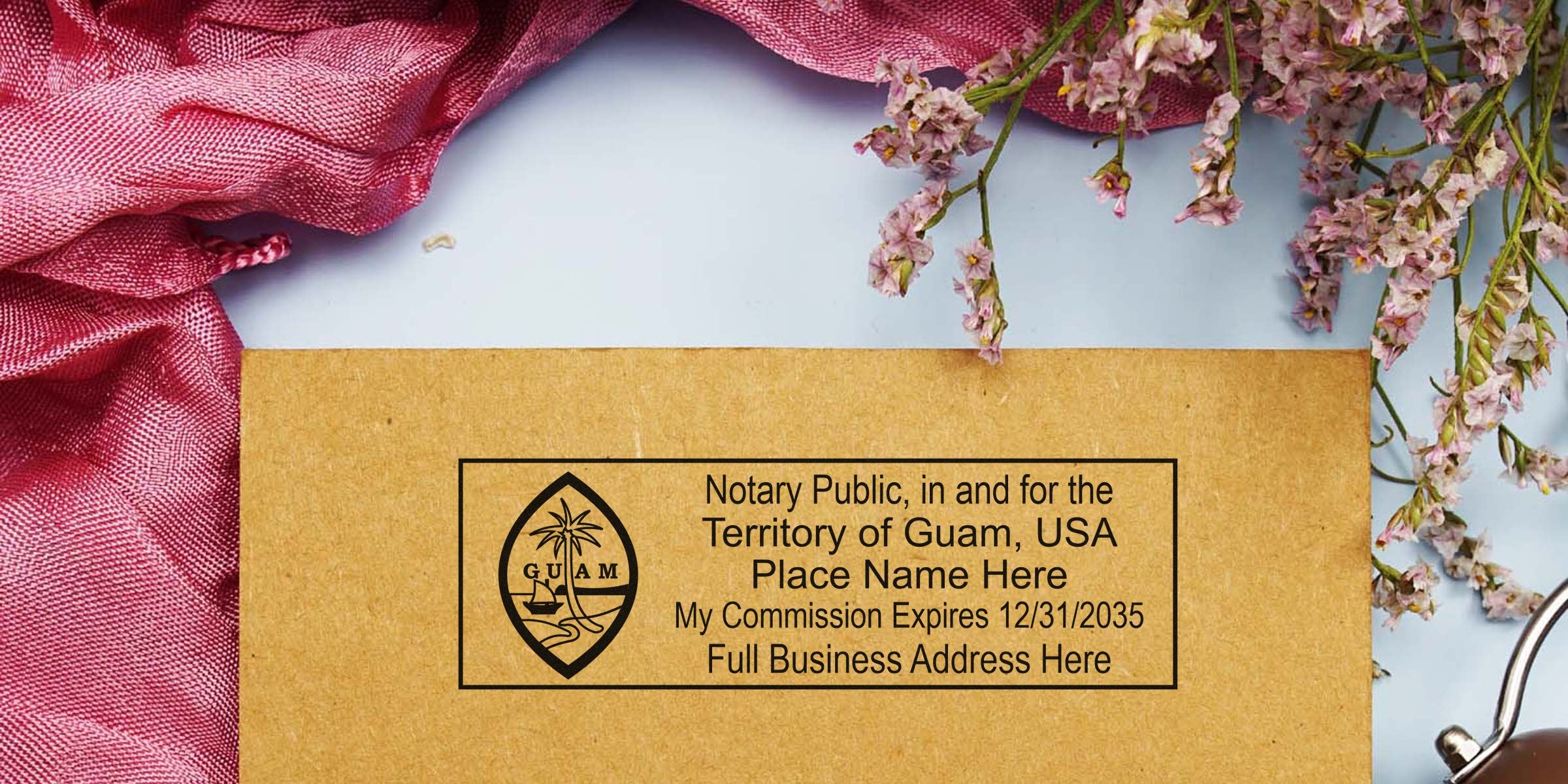 Brown envelope with a black Guam notary public stamp and commission expiration date, styled with pink fabric drape and pale pink dried flowers for stationery or legal branding