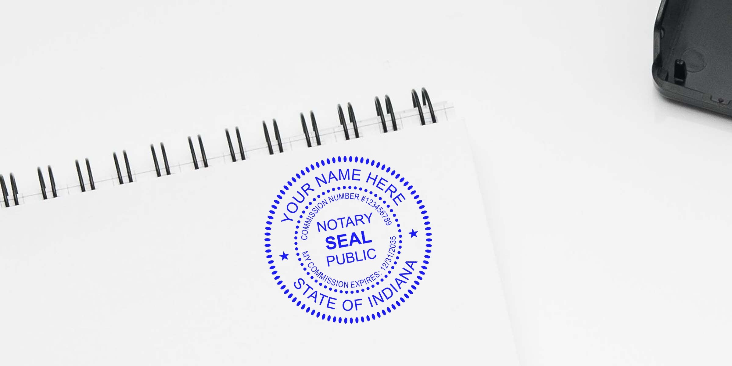 Blue circular notary public seal stamped on white spiral-bound notebook page reading "Notary Seal Public, State of Indiana" — mock personalized notary stamp for Indiana documents, office stationery and legal paperwork.