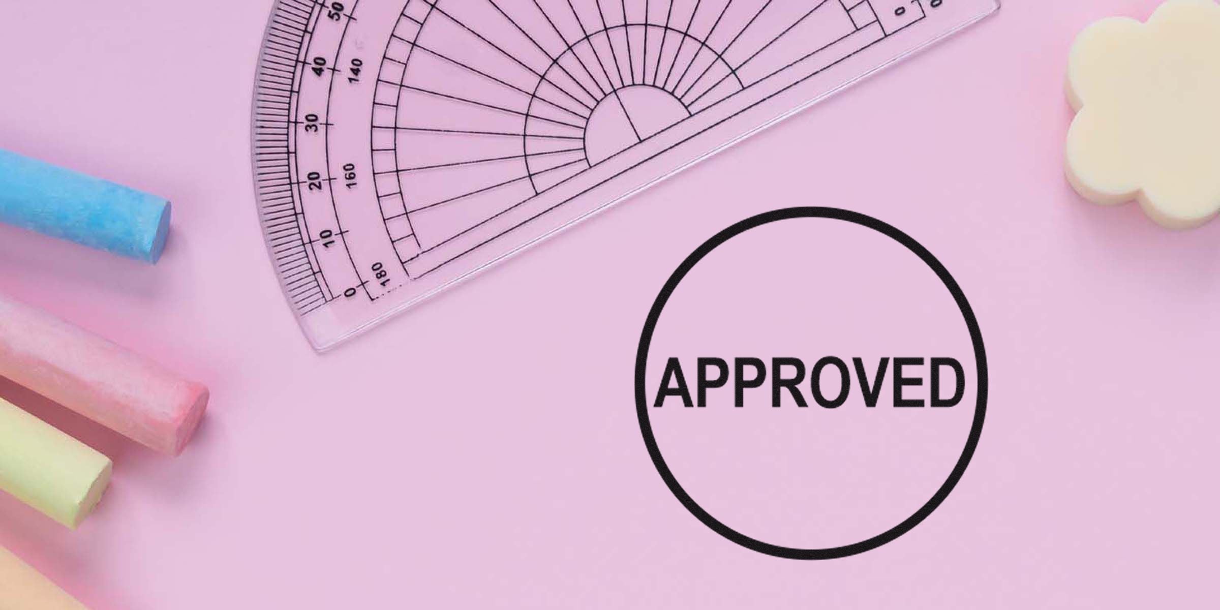 A pink background with a circular “APPROVED” stamp near a ruler and chalk sticks.