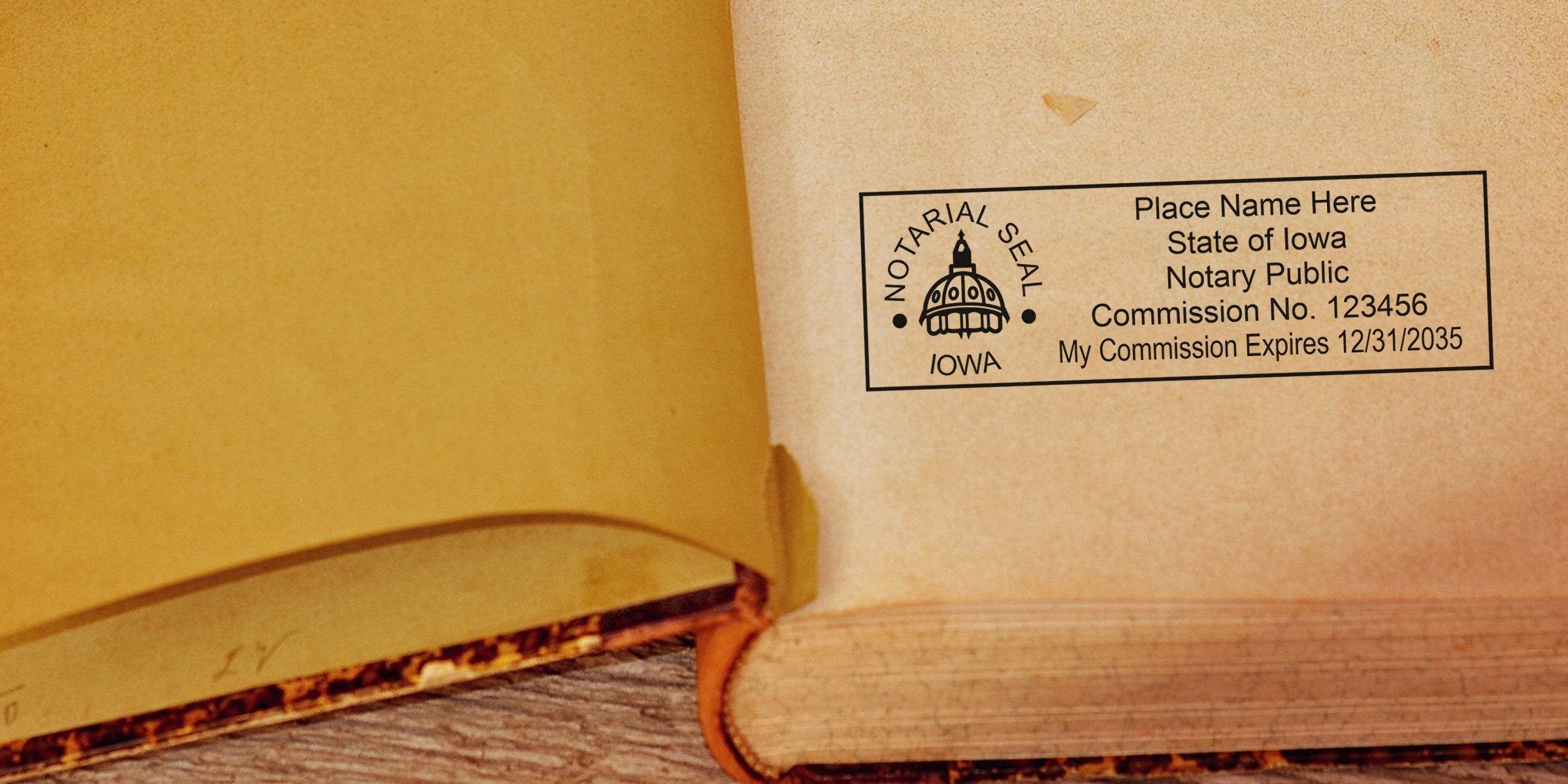 Open vintage book laid on wood with an Iowa notarial seal stamp and notary public commission details printed on the inside cover.