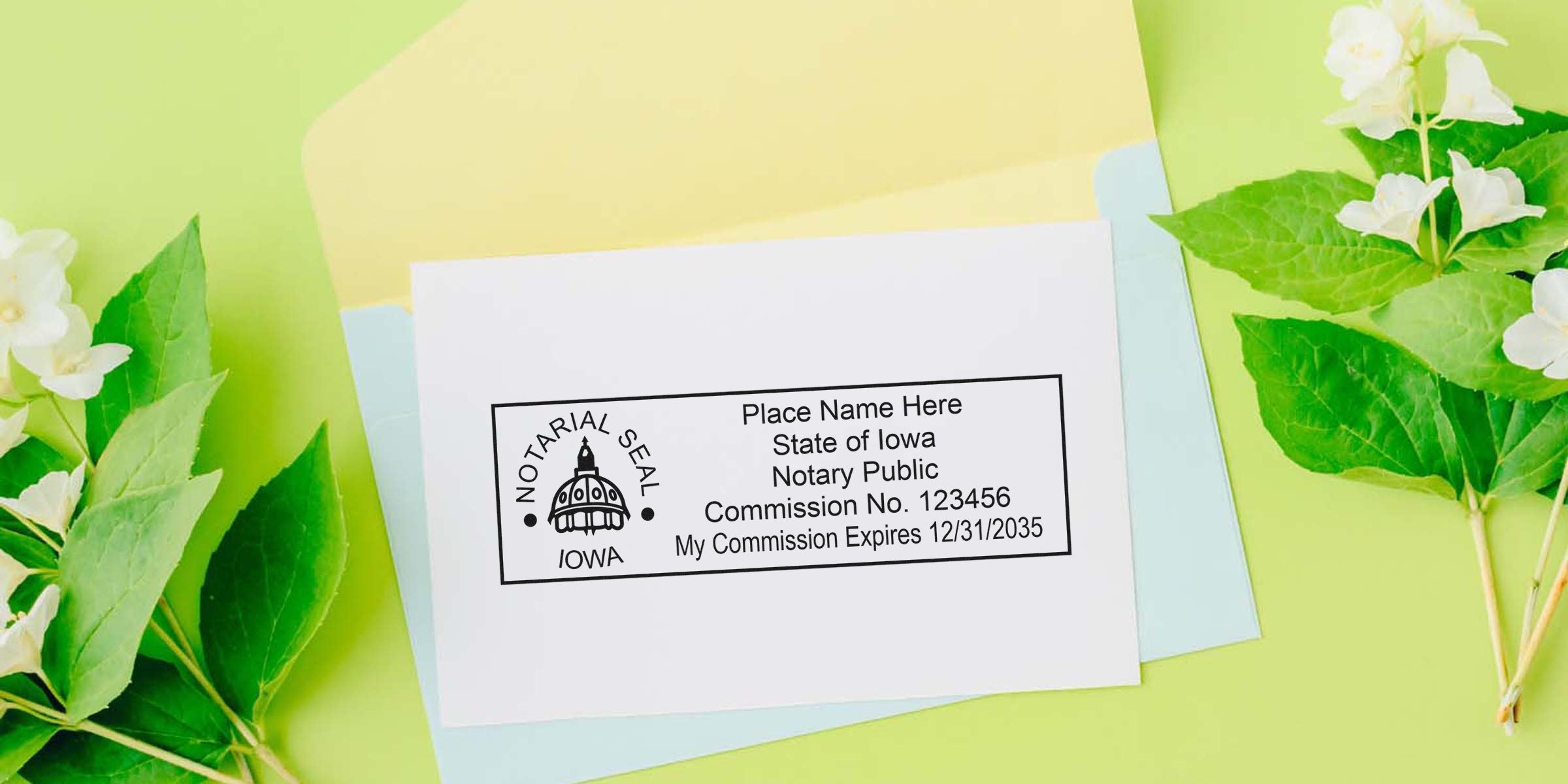 Iowa notary public rectangular seal stamp sample on white card showing commission number and expiration date, placed on pastel envelopes with green leaves and white flowers — notary seal and stationery background