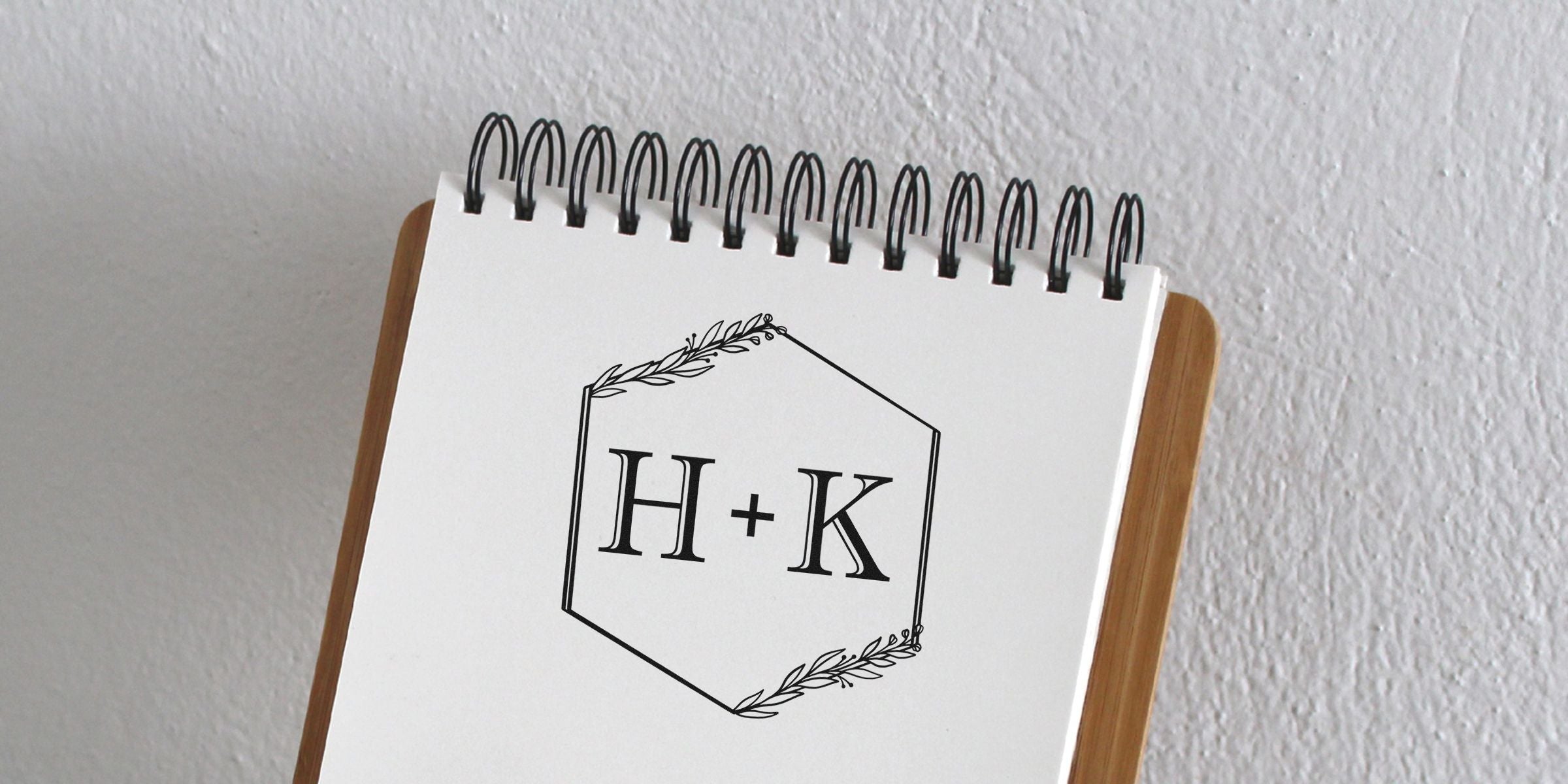 Notebook page with a hexagonal frame containing the letters H + K.