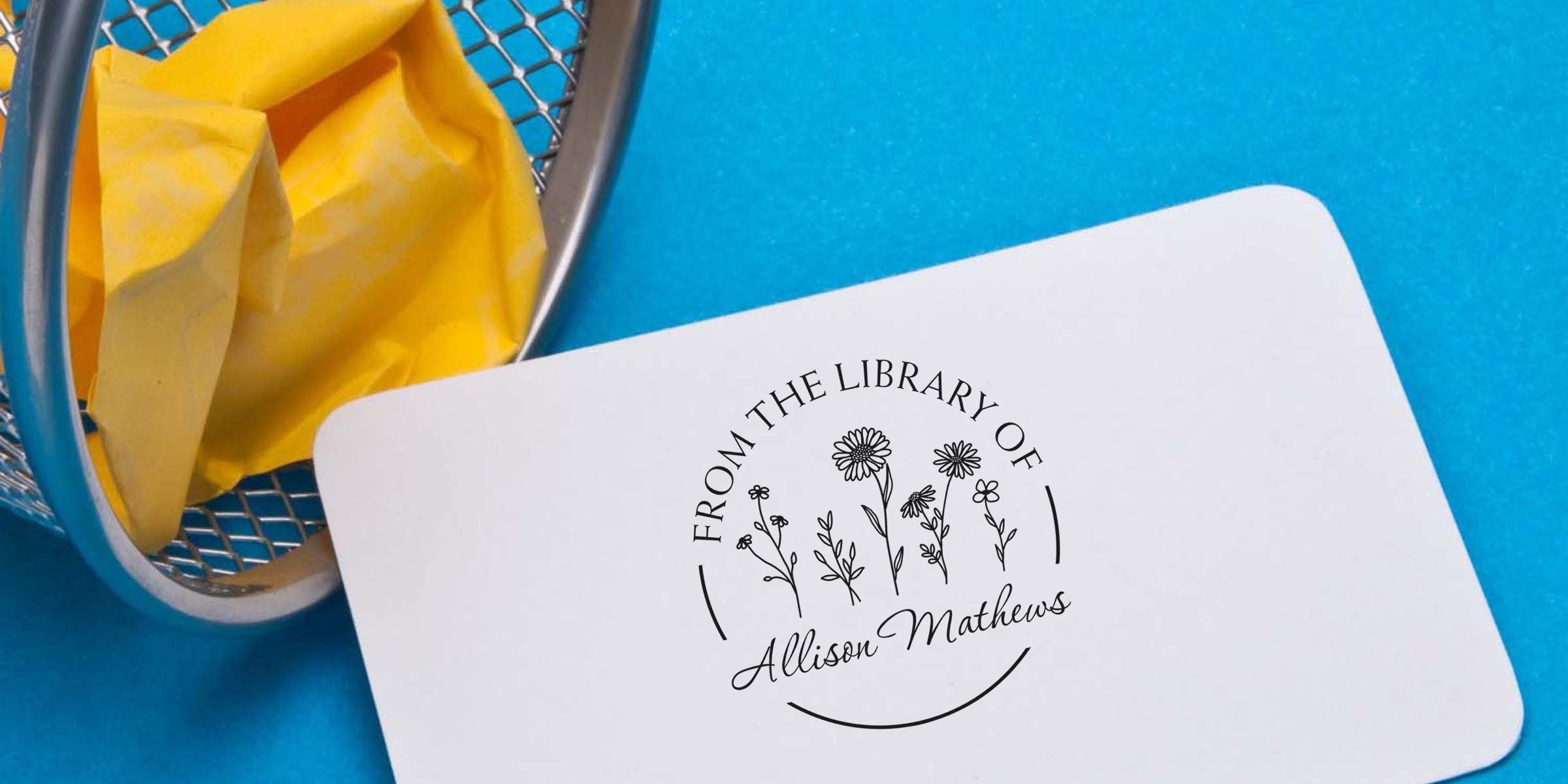 White name tag/card with a circular floral logo reading “From the Library of Allison Mathews.”